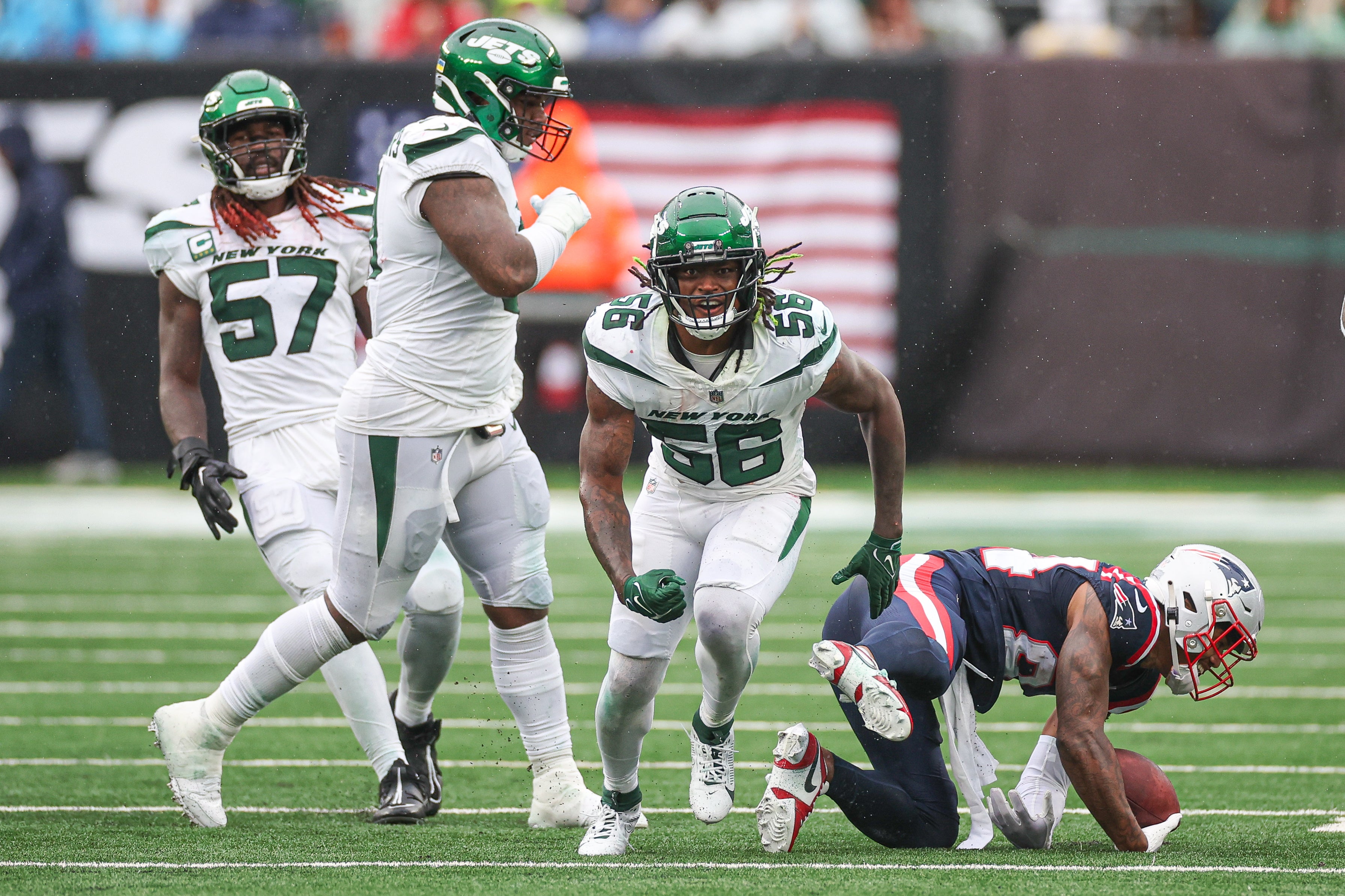 New York Jets linebacker Quincy Williams (56) celebrates after a tackle against New England Patriots wide receiver Kendrick Bourne (84) during the second half at MetLife Stadium.