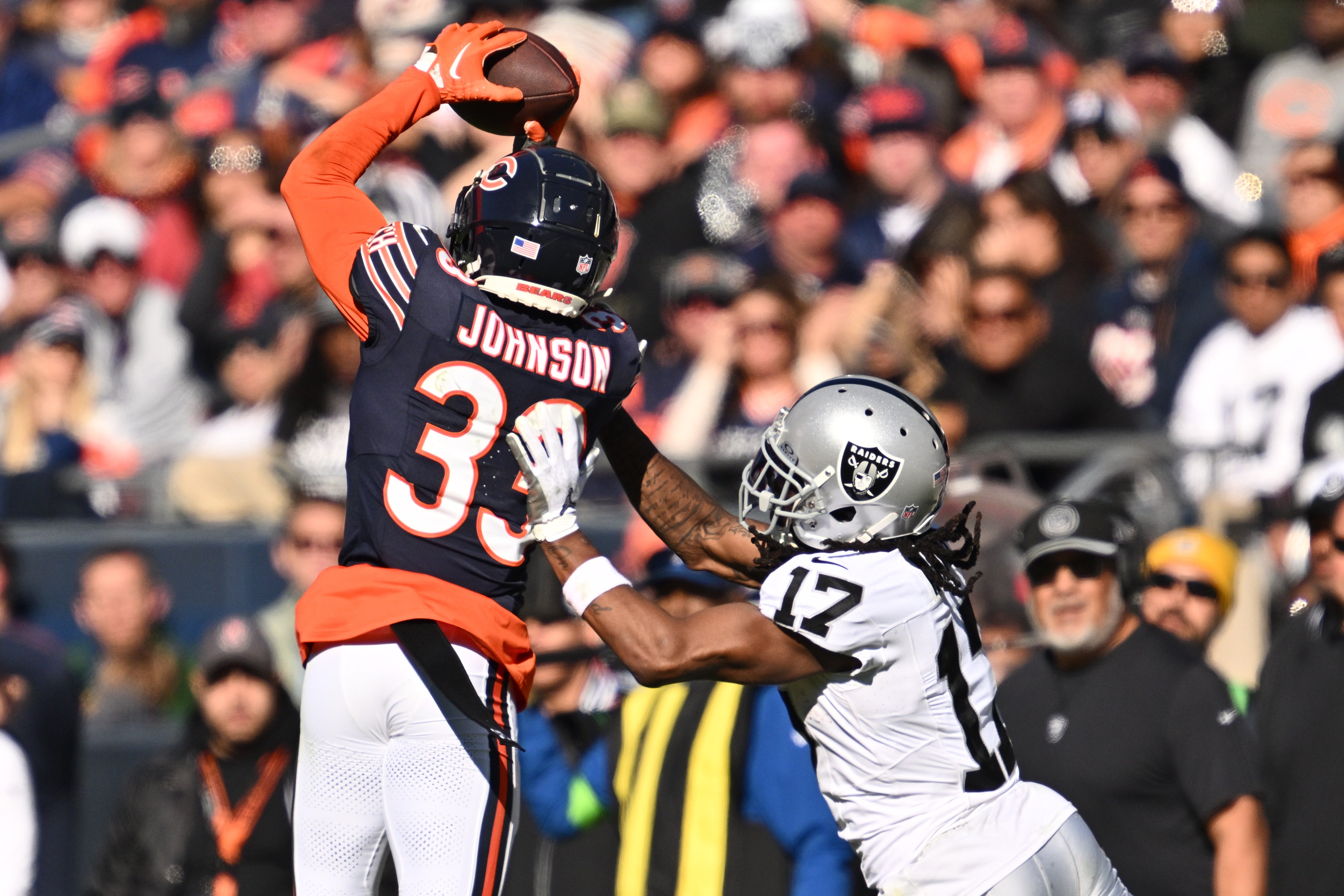 Oct 22, 2023; Chicago, Illinois, USA; Chicago Bears defensive back Jaylon Johnson (33) steps in front of Las Vegas Raiders wide receiver Davante Adams (17) to intercept a pass before returning the ball for a touchdown in the fourth quarter at Soldier Field.