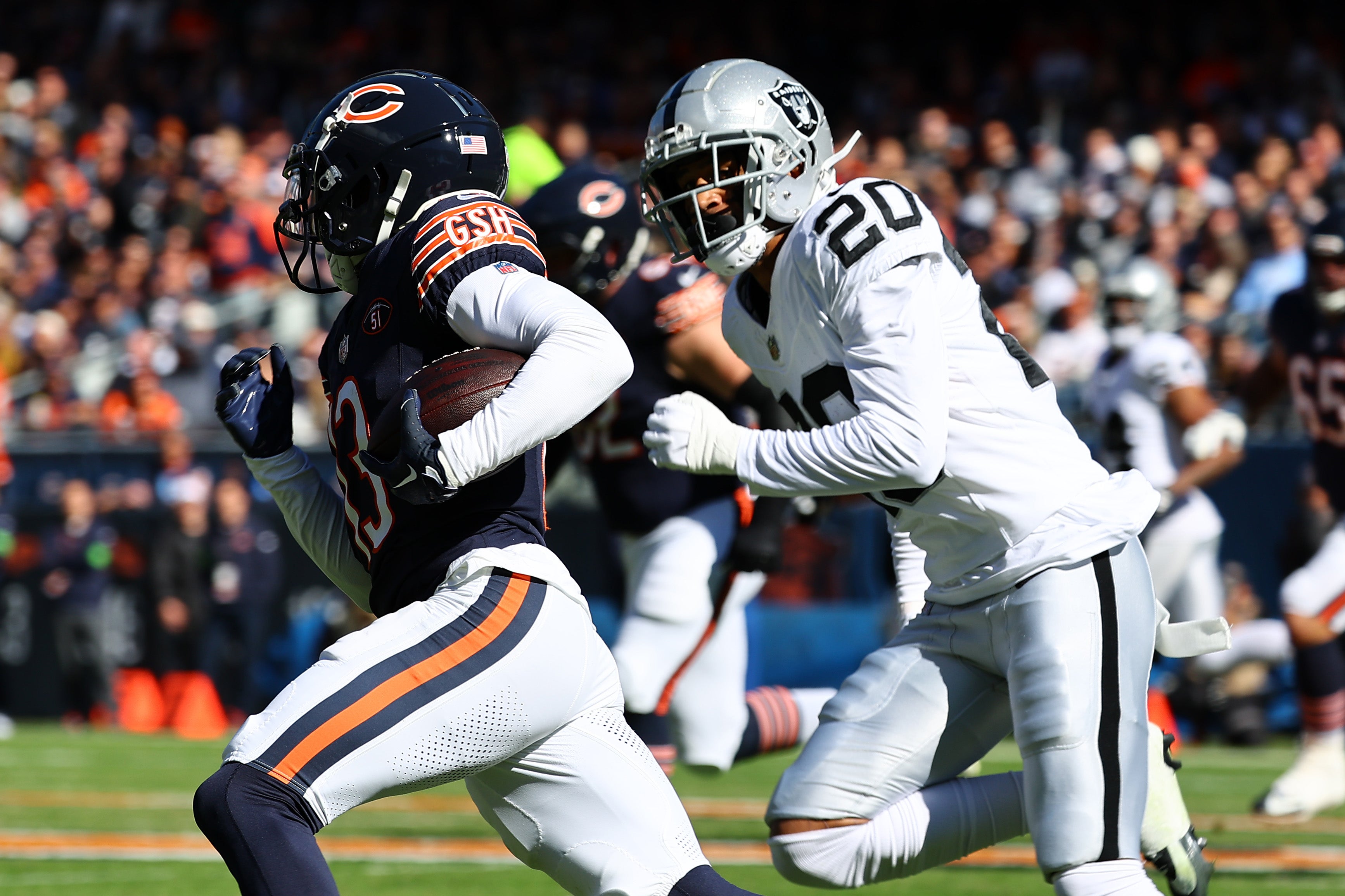 Oct 22, 2023; Chicago, Illinois, USA; Chicago Bears wide receiver Tyler Scott (13) runs with the ball after a catch past Las Vegas Raiders safety Isaiah Pola-Mao (20) in the first half of the game at Soldier Field.