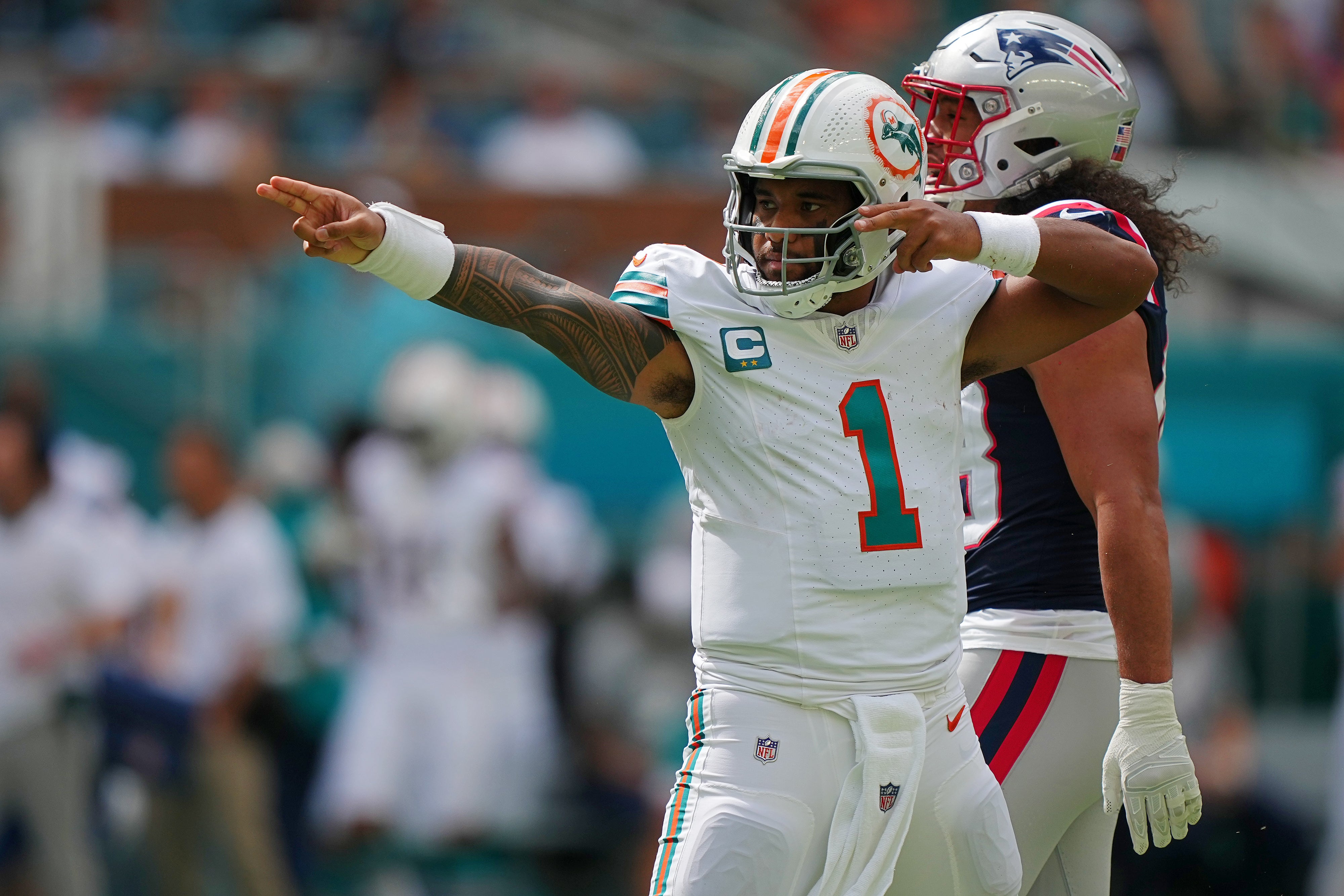 Miami Dolphins quarterback Tua Tagovailoa (1) celebrates after running the ball for a first down against the New England Patriots during the first half at Hard Rock Stadium.