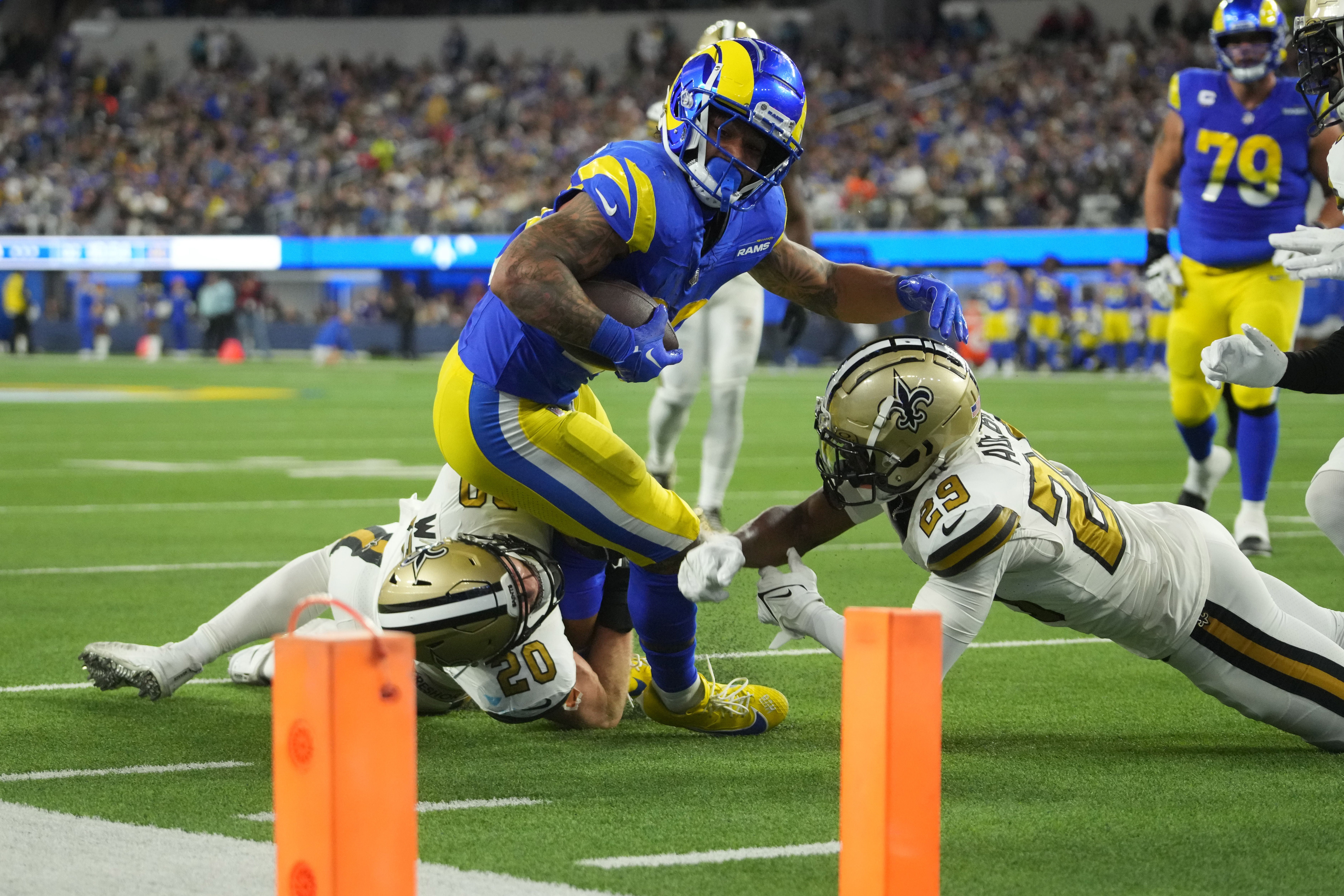 Dec 21, 2023; Inglewood, California, USA; Los Angeles Rams running back Kyren Williams (23) carries the ball against New Orleans Saints cornerback Paulson Adebo (29) in the first half at SoFi Stadium. Mandatory Credit: Kirby Lee-USA TODAY Sports