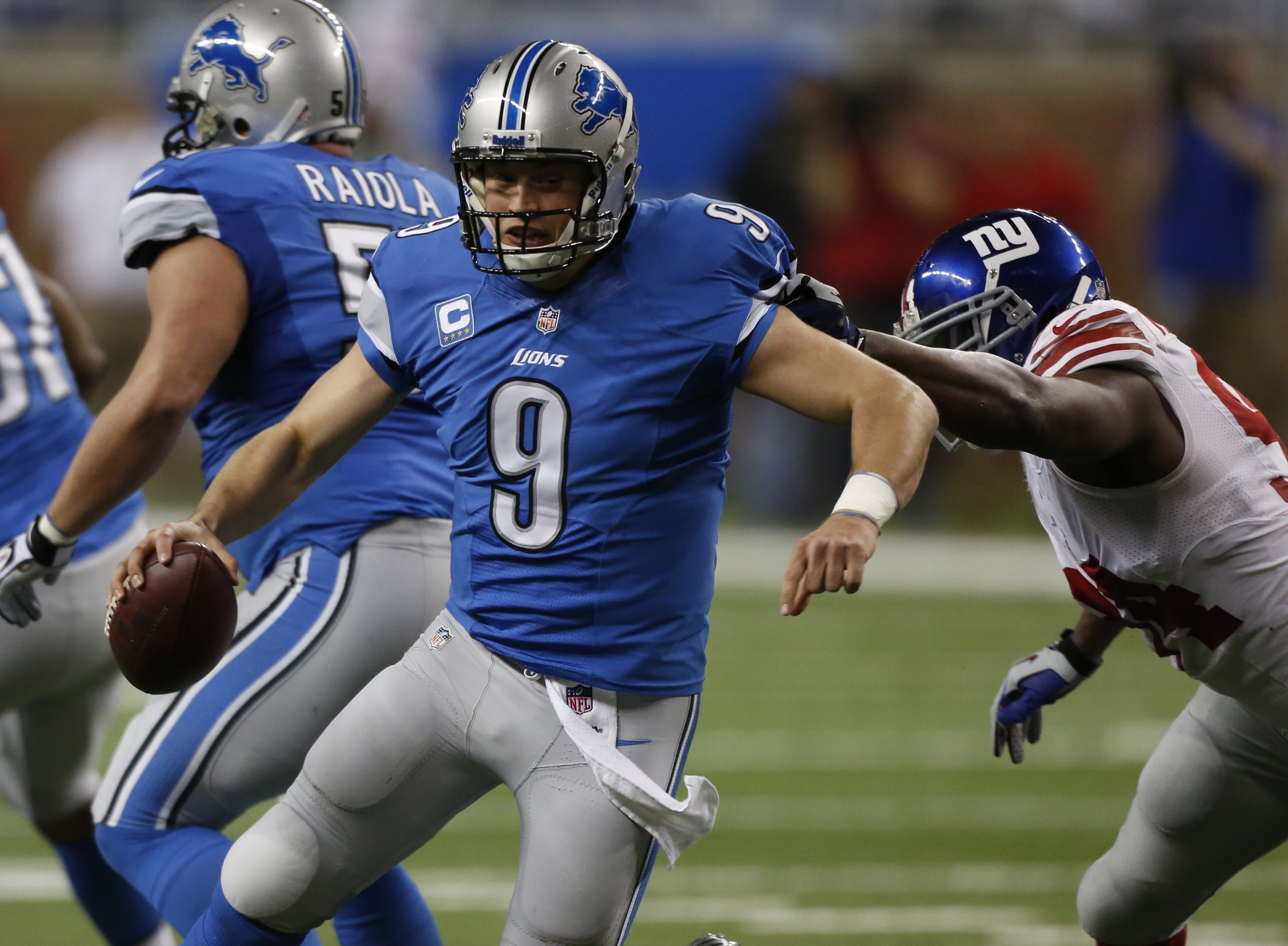Detroit Lions Matthew Stafford ran out of the grasp of New York Giants Mathias Kiwanuka in the second quarter of their in Detroit, Sunday, December 22, 2013.