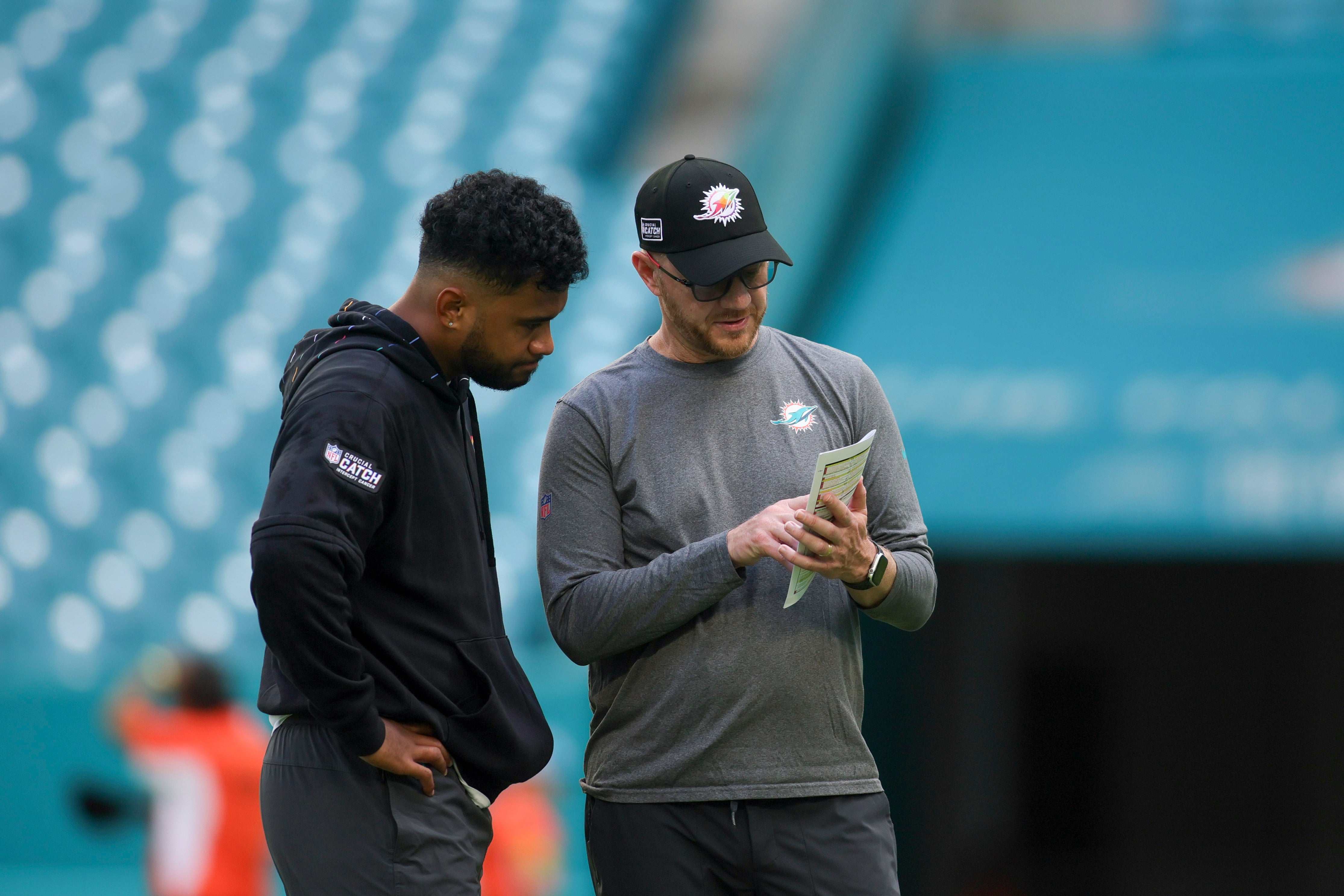 Oct 8, 2023; Miami Gardens, Florida, USA; Miami Dolphins quarterback Tua Tagovailoa (1) talks to quarterbacks/passing game coordinator Darrell Bevell prior to the game against the New York Giants at Hard Rock Stadium.