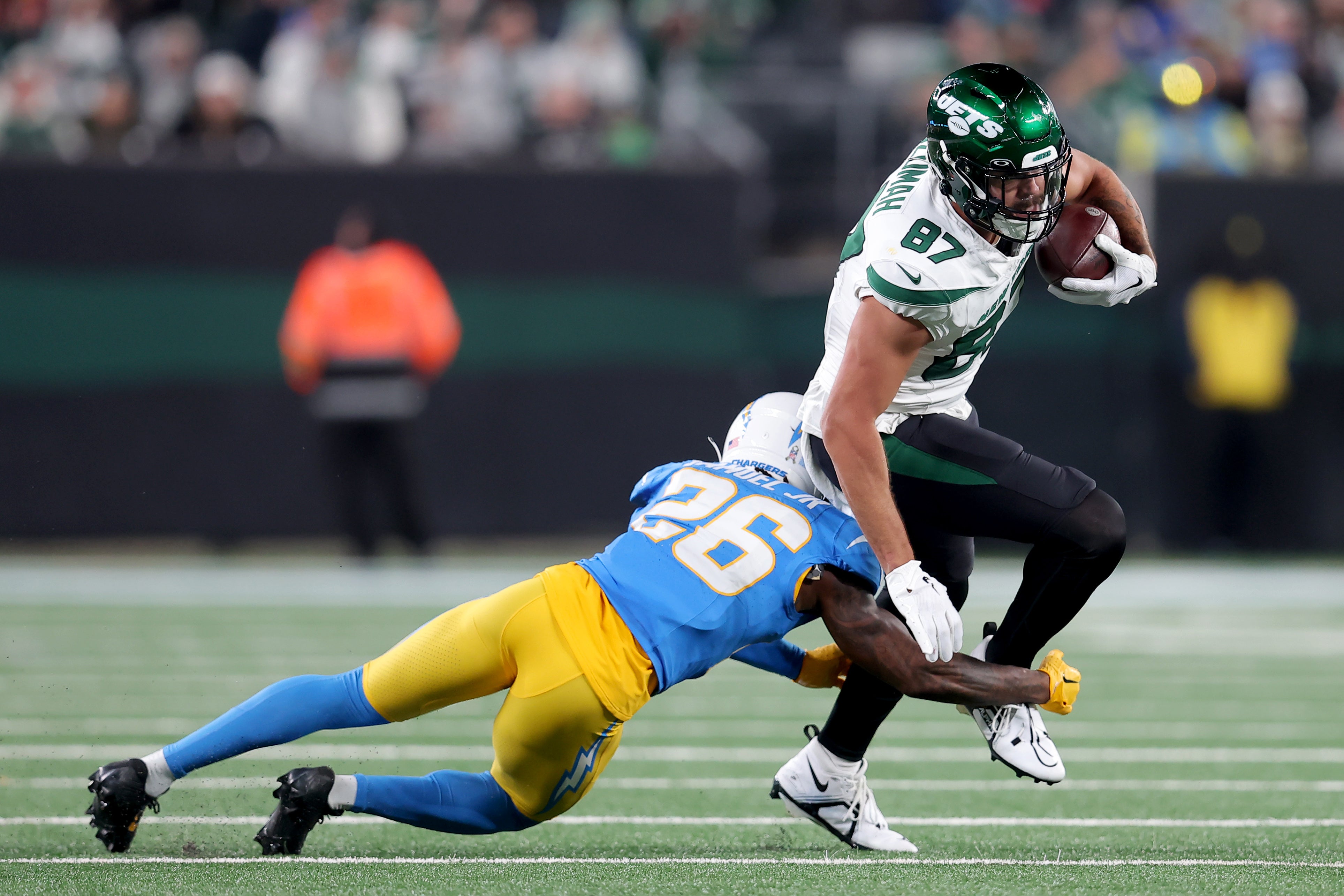 New York Jets tight end C.J. Uzomah (87) runs with the ball against Los Angeles Chargers cornerback Asante Samuel Jr. (26) during the third quarter at MetLife Stadium.