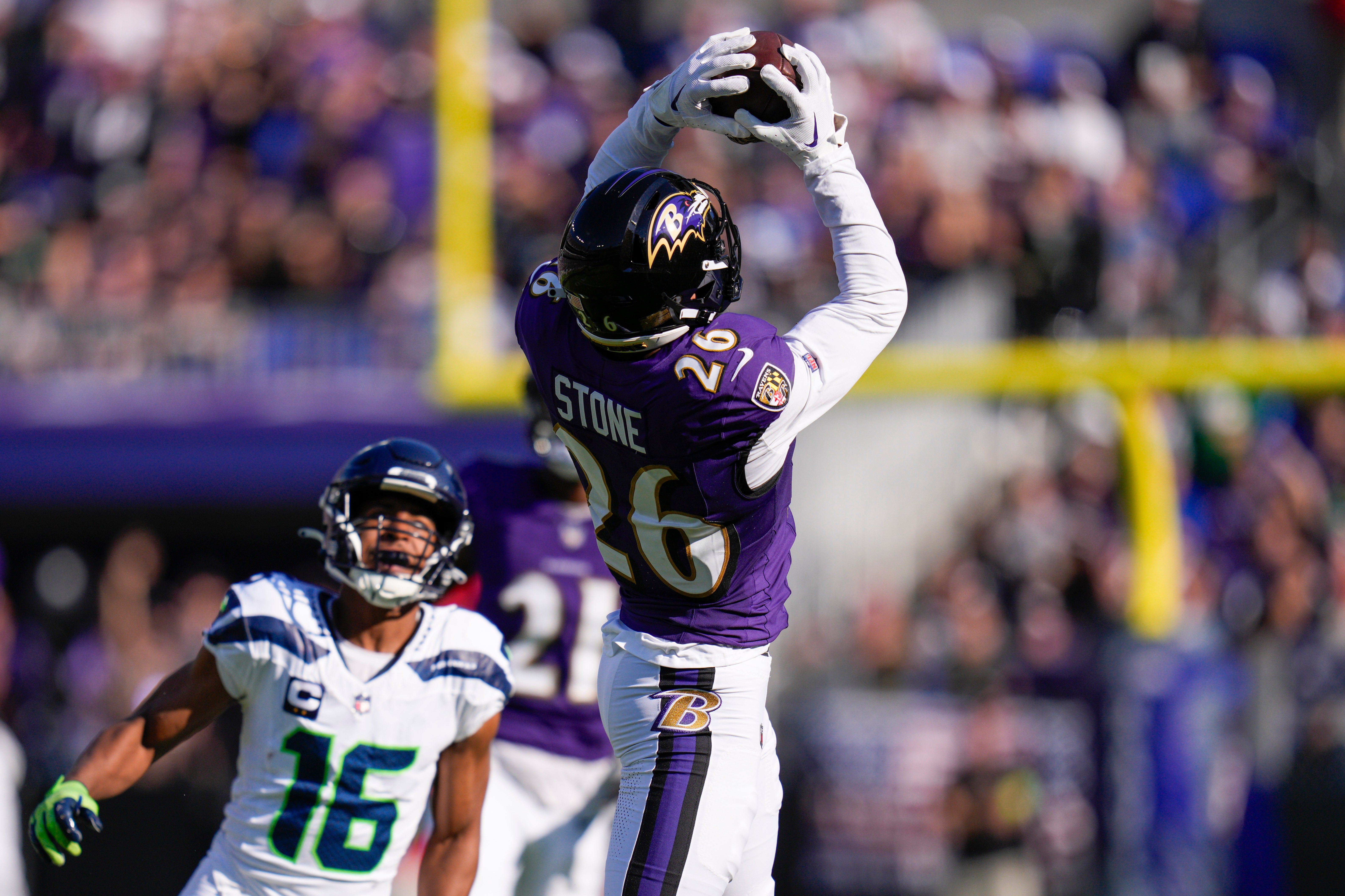 Nov 5, 2023; Baltimore, Maryland, USA; Baltimore Ravens safety Geno Stone (26) catches an interception against the Seattle Seahawks during the first half at M&T Bank Stadium.