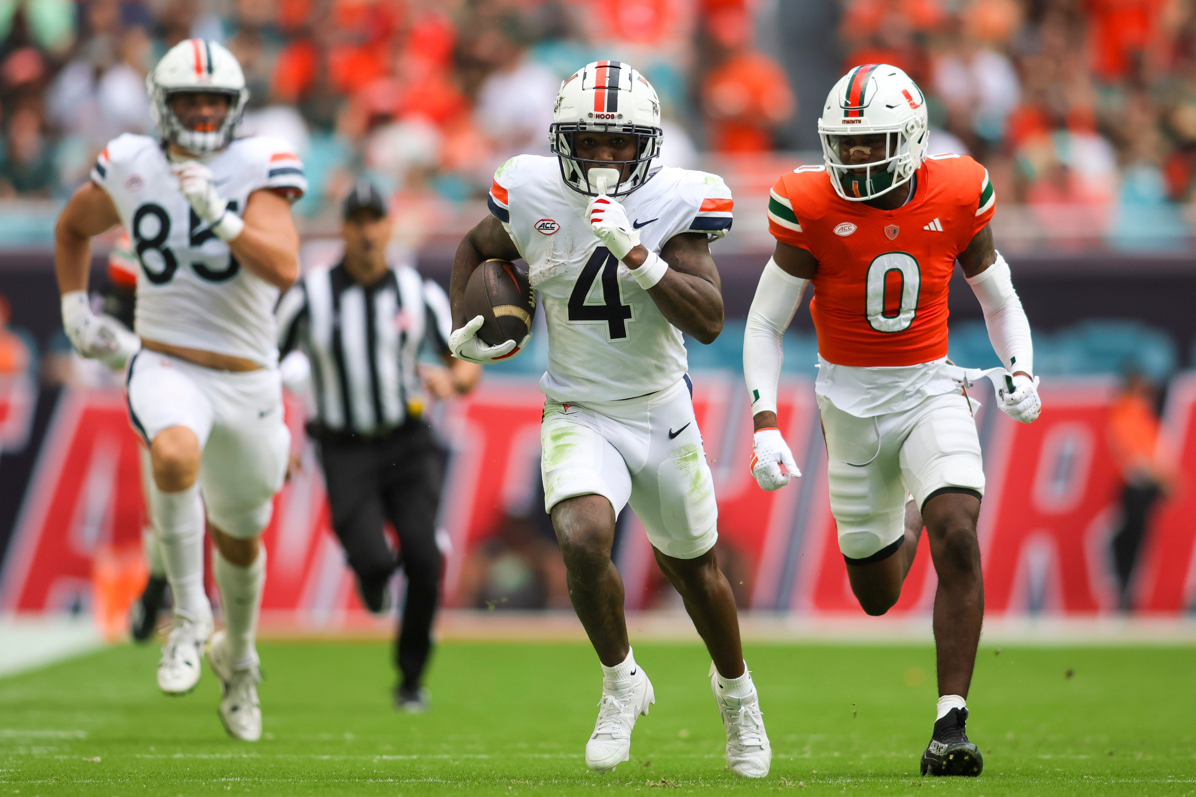 Oct 28, 2023; Miami Gardens, Florida, USA; Virginia Cavaliers wide receiver Malik Washington (4) runs with the football ahead of Miami Hurricanes cornerback Te'Cory Couch (0) during the second quarter at Hard Rock Stadium.