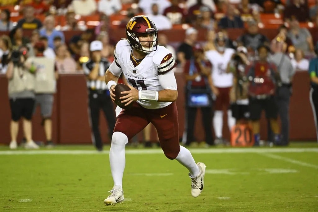 Washington Commanders quarterback Jake Fromm (11) rolls out against the Cincinnati Bengals during the second half at FedExField.