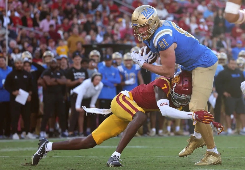 UCLA Bruins tight end Hudson Habermehl (81) scores a touchdown against USC Trojans safety Calen Bullock (7) during the fourth quarter at United Airlines Field at Los Angeles Memorial Coliseum.