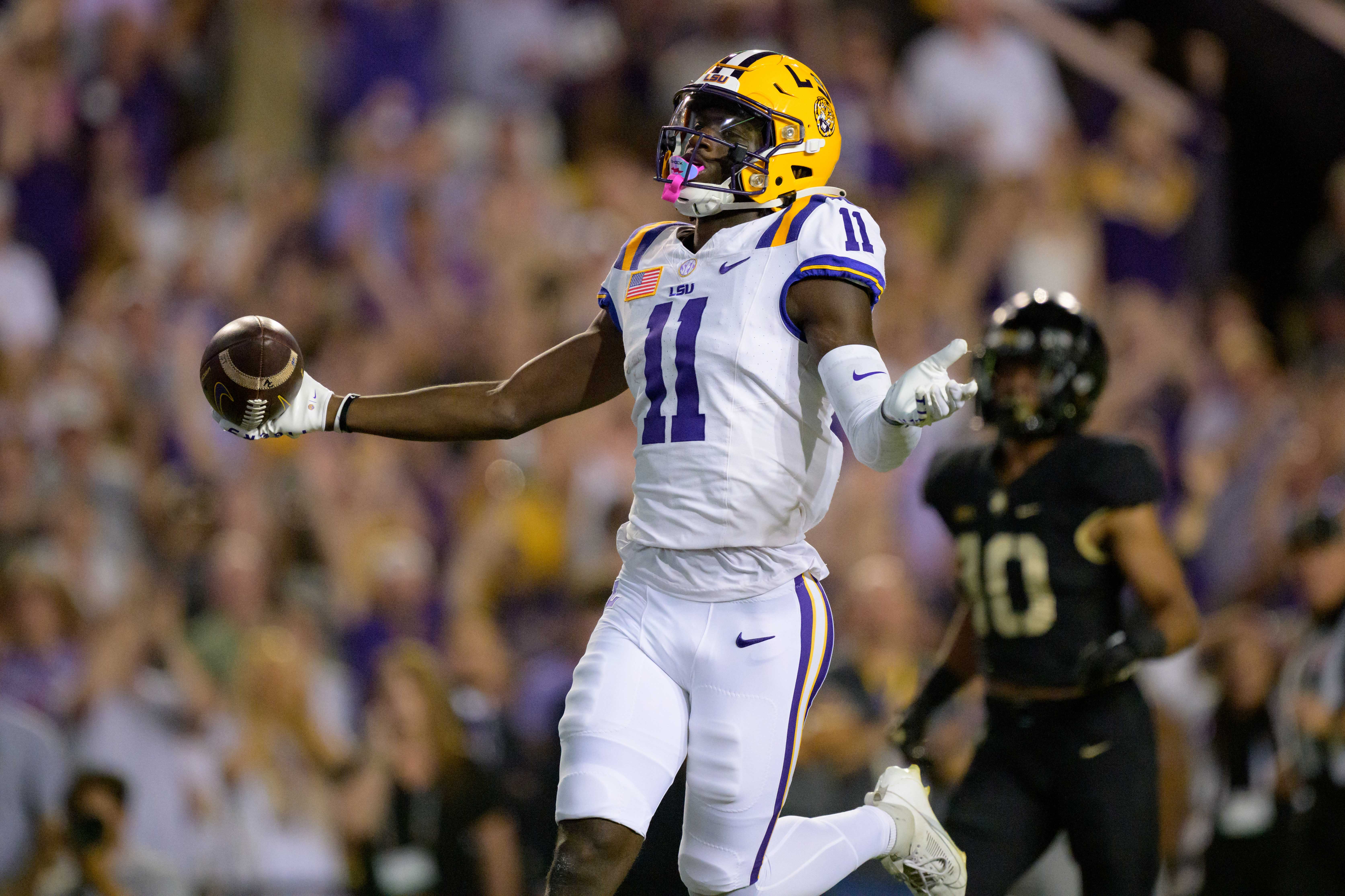 Oct 21, 2023; Baton Rouge, Louisiana, USA; LSU Tigers wide receiver Brian Thomas Jr. (11) celebrates after scoring a touchdown against Army Black Knights defensive back Cameron Jones (10) during the first quarter at Tiger Stadium.