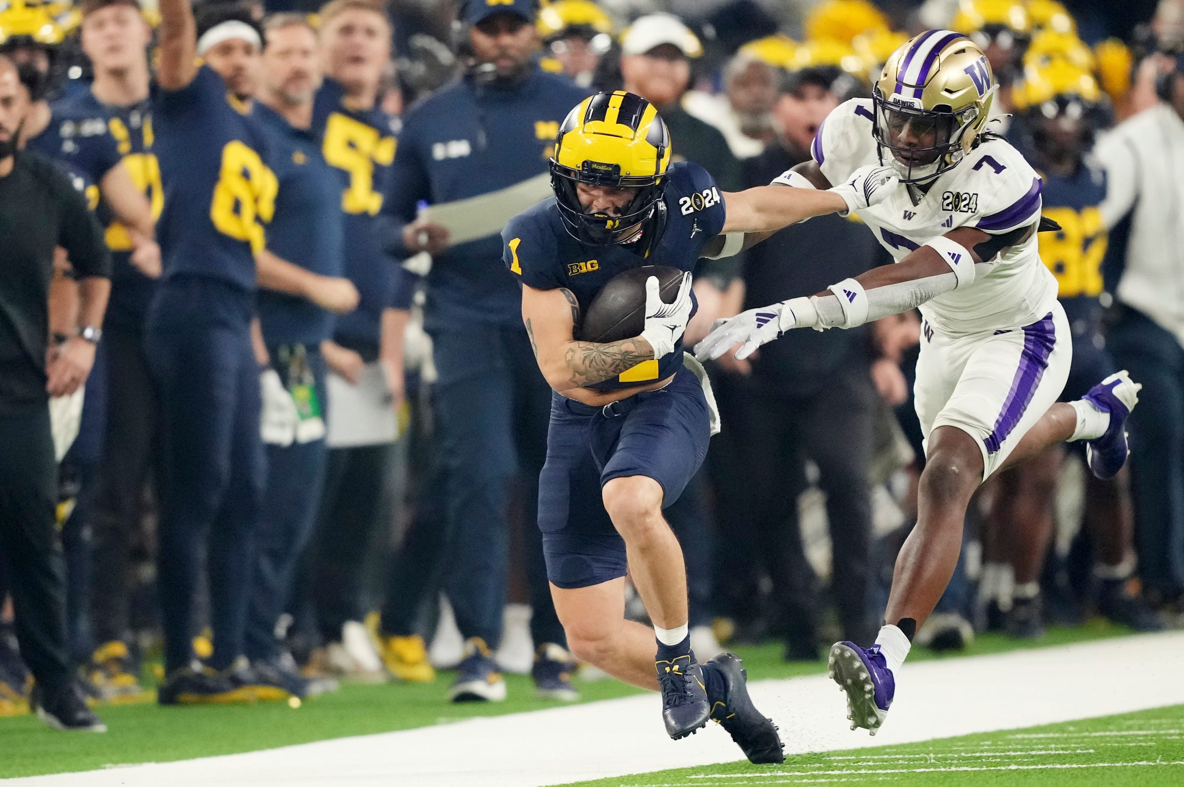 Michigan wide receiver Roman Wilson runs the ball around Washington cornerback Dominique Hampton during the first quarter of the College Football Playoff national championship game against Washington at NRG Stadium in Houston, Texas on Monday, Jan. 8, 2024.