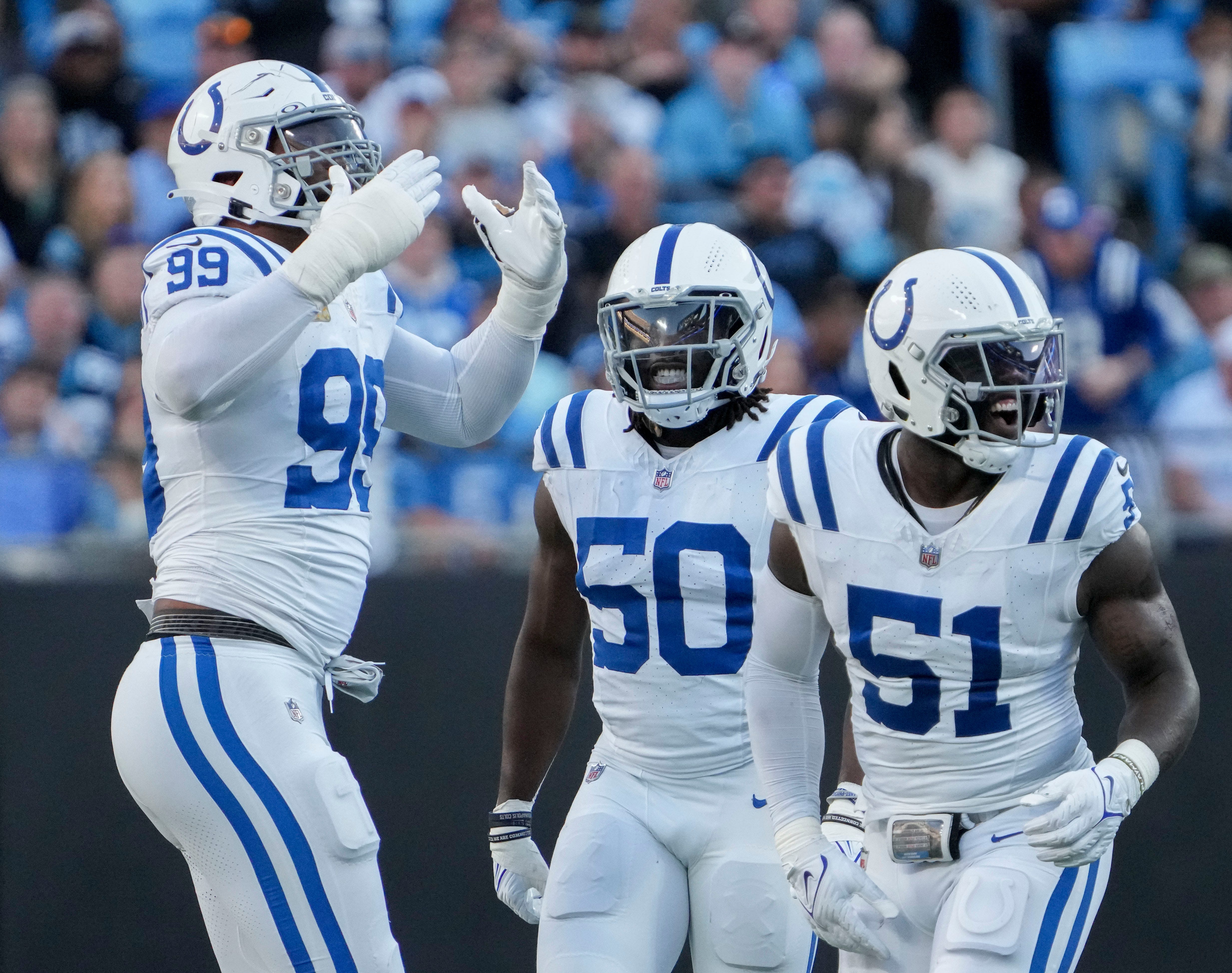 Indianapolis Colts defensive tackle DeForest Buckner (99) blows kisses to the crowd as Indianapolis Colts linebacker Segun Olubi (50) and Indianapolis Colts defensive end Kwity Paye (51) celebrate a sack Sunday, Nov. 5, 2023, during a game against the Carolina Panthers at Bank of America Stadium in Charlotte.