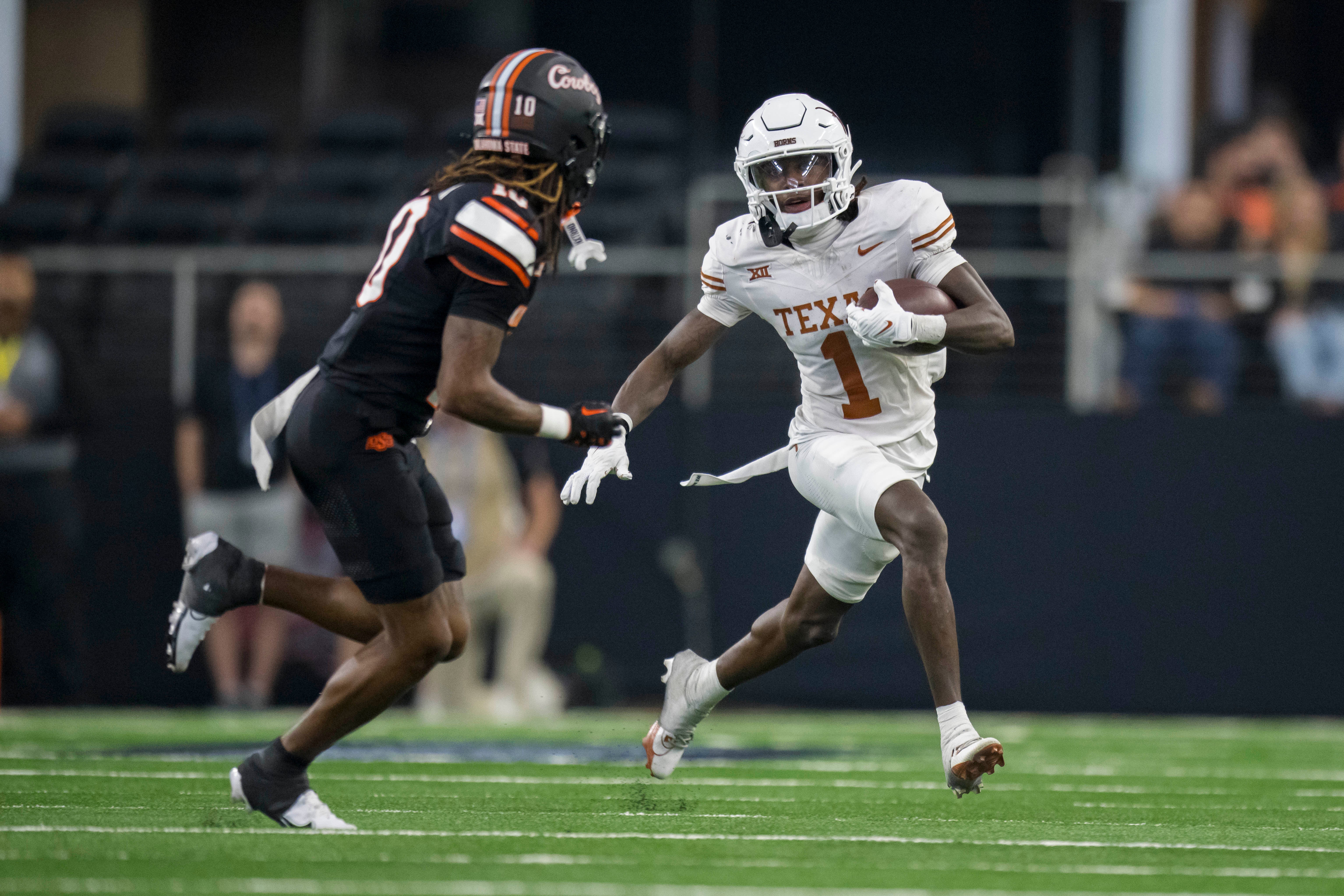 Dec 2, 2023; Arlington, TX, USA; Oklahoma State Cowboys cornerback Kale Smith (10) and Texas Longhorns wide receiver Xavier Worthy (1) in action during the game between the Texas Longhorns and the Oklahoma State Cowboys at AT&T Stadium.