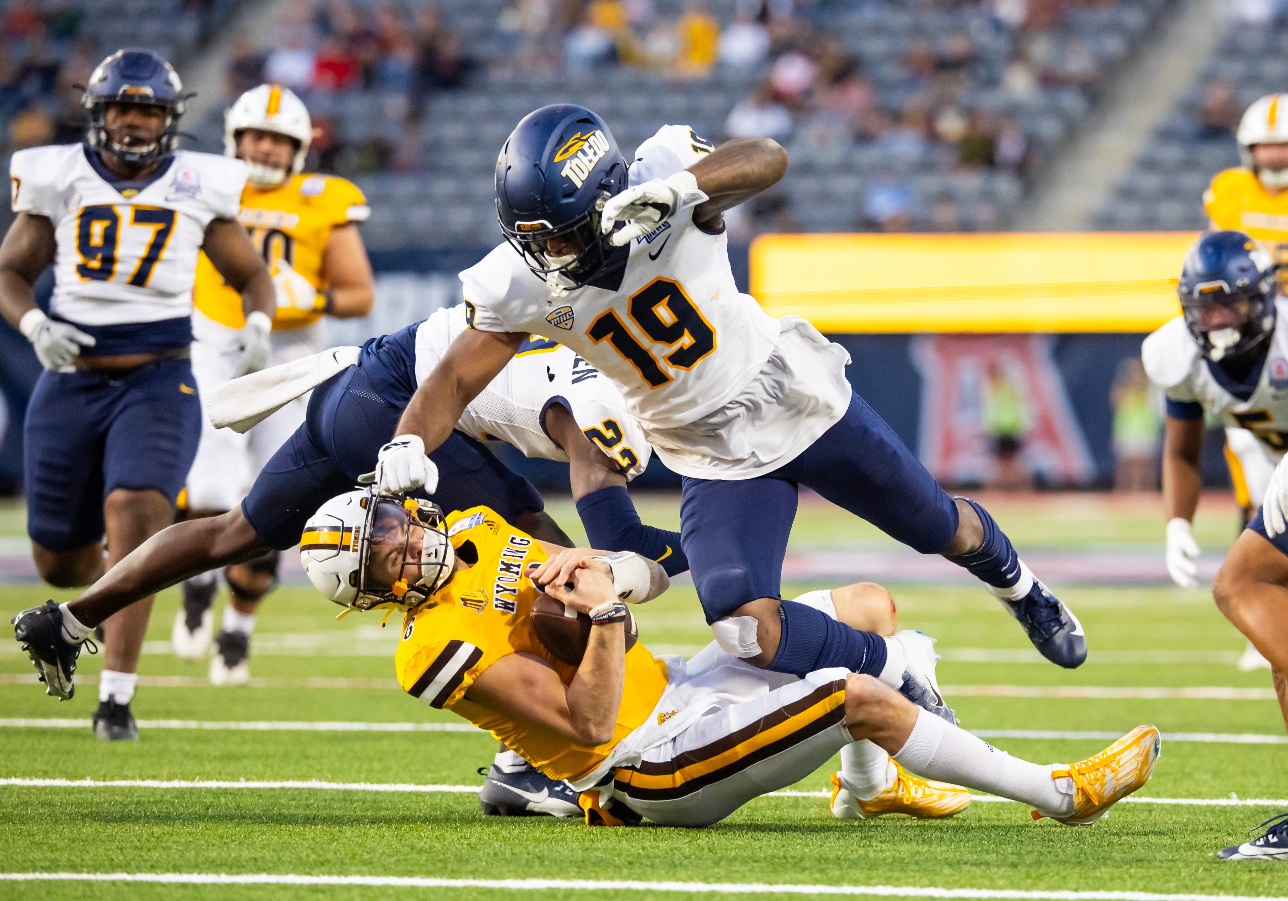 Dec 30, 2023; Tucson, AZ, USA; Wyoming Cowboys quarterback Andrew Peasley (6) is hit and tackled by Toledo Rockets linebacker Dallas Gant (19) during the second half in the Arizona Bowl at Arizona Stadium.