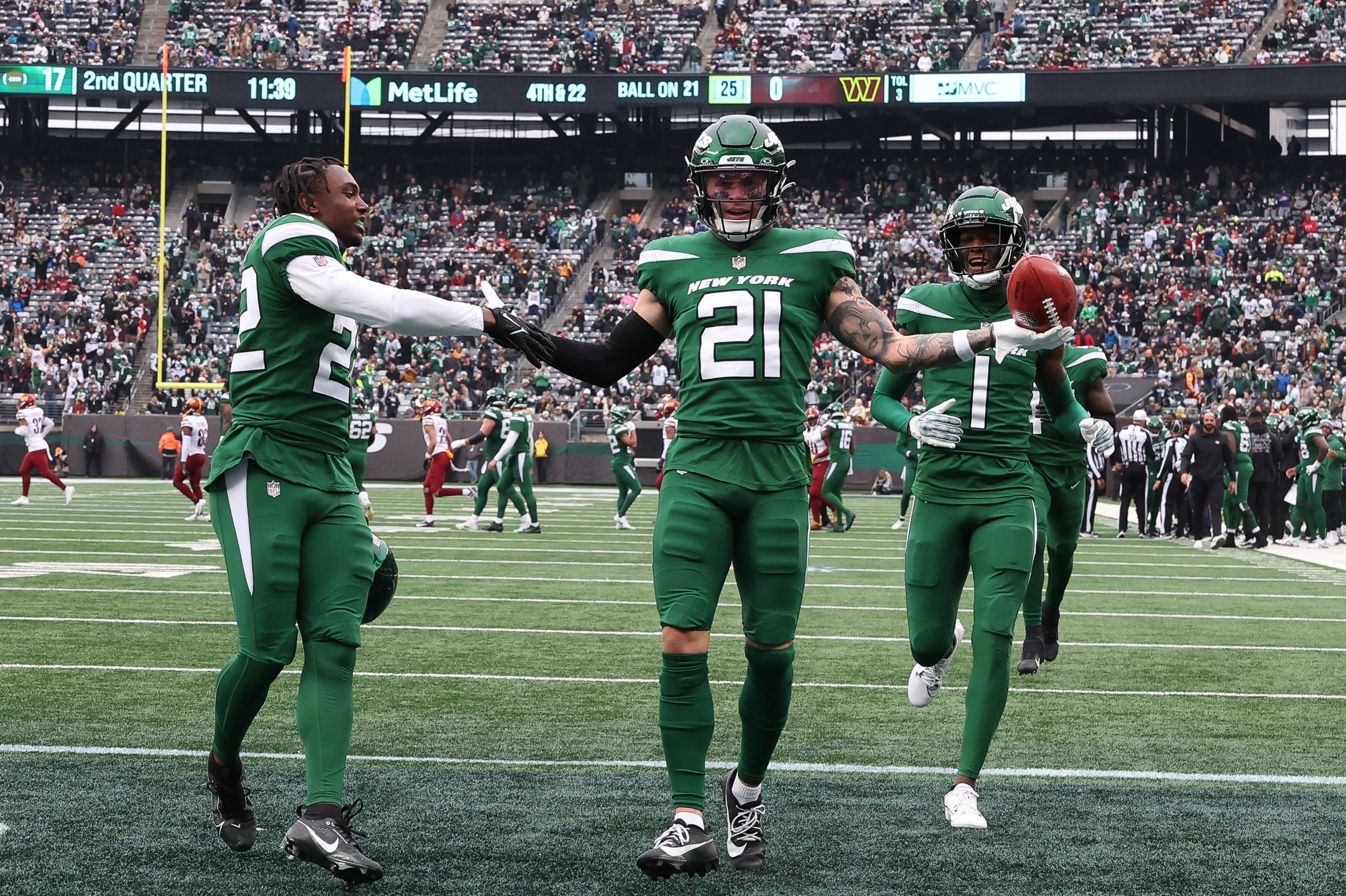 New York Jets safety Ashtyn Davis (21) celebrates his fumble recovery with safety Tony Adams (22) and cornerback Sauce Gardner (1) during the first half against the Washington Commanders at MetLife Stadium.