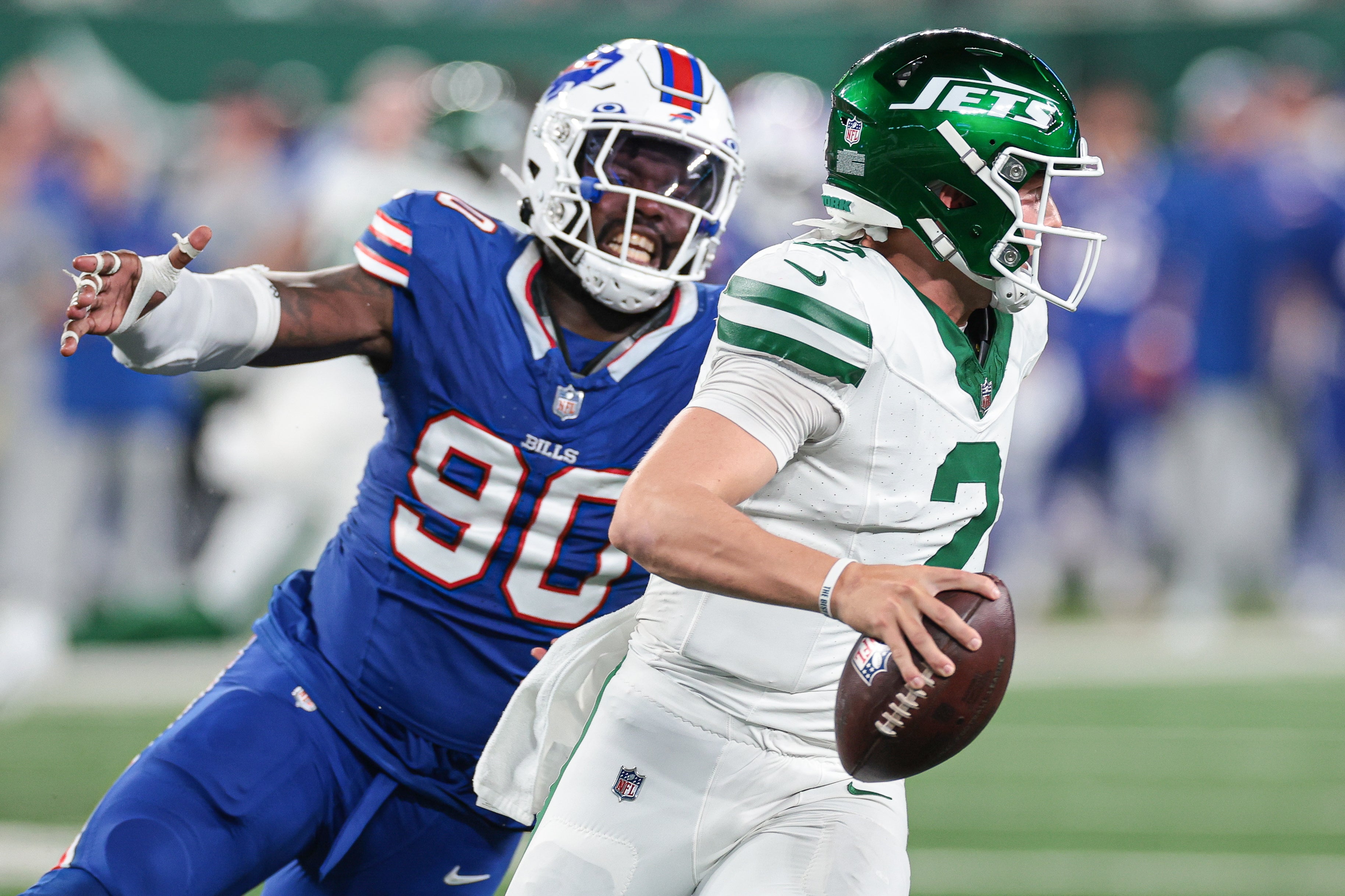 Sep 11, 2023; East Rutherford, New Jersey, USA; New York Jets quarterback Zach Wilson (2) avoids being sacked by Buffalo Bills defensive end Shaq Lawson (90) during the second half at MetLife Stadium.