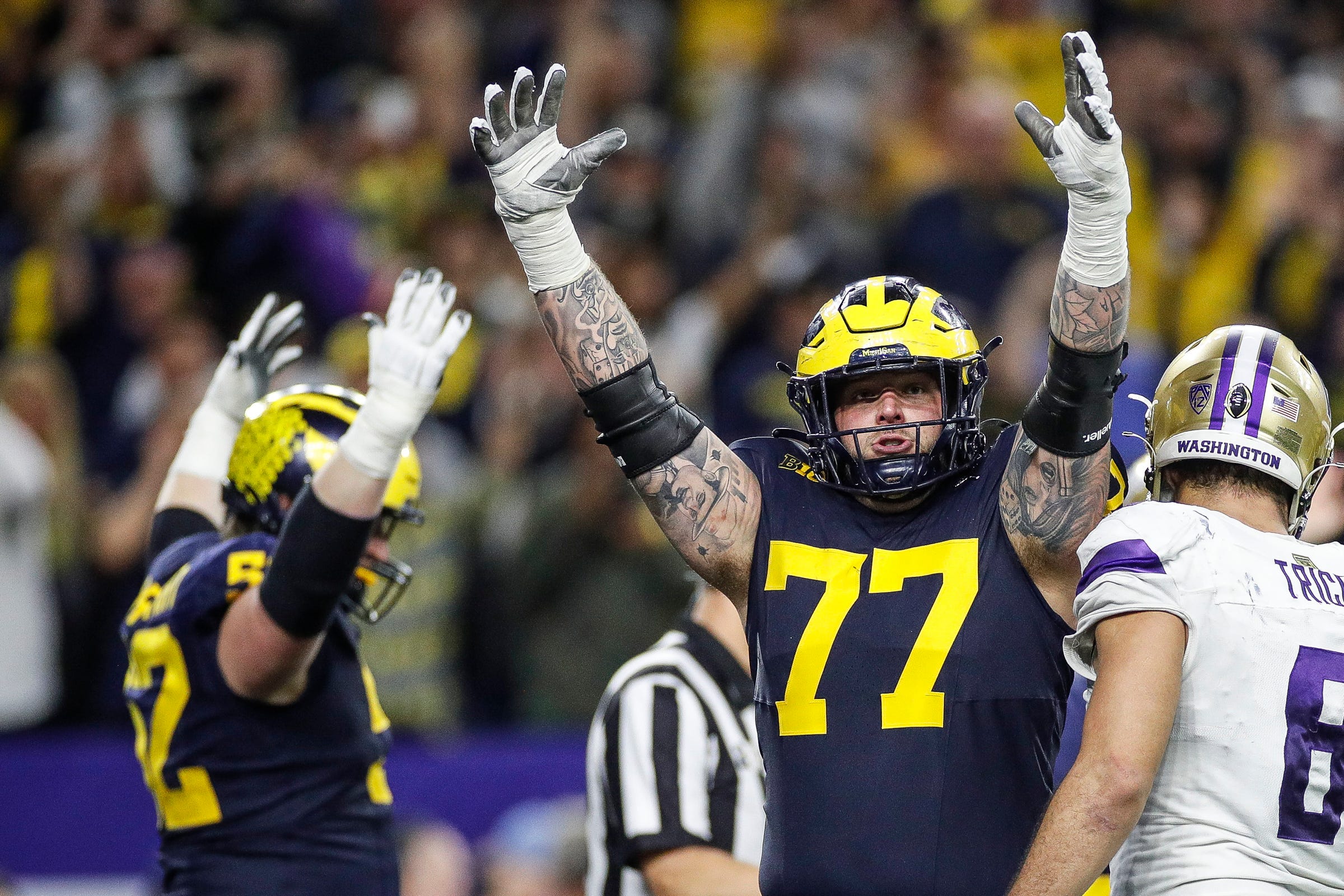 Michigan offensive lineman Trevor Keegan, center, celebrate a touchdown scored by running back Blake Corum against Washington during the second half of U-M's 34-13 win in the College Football Playoff.