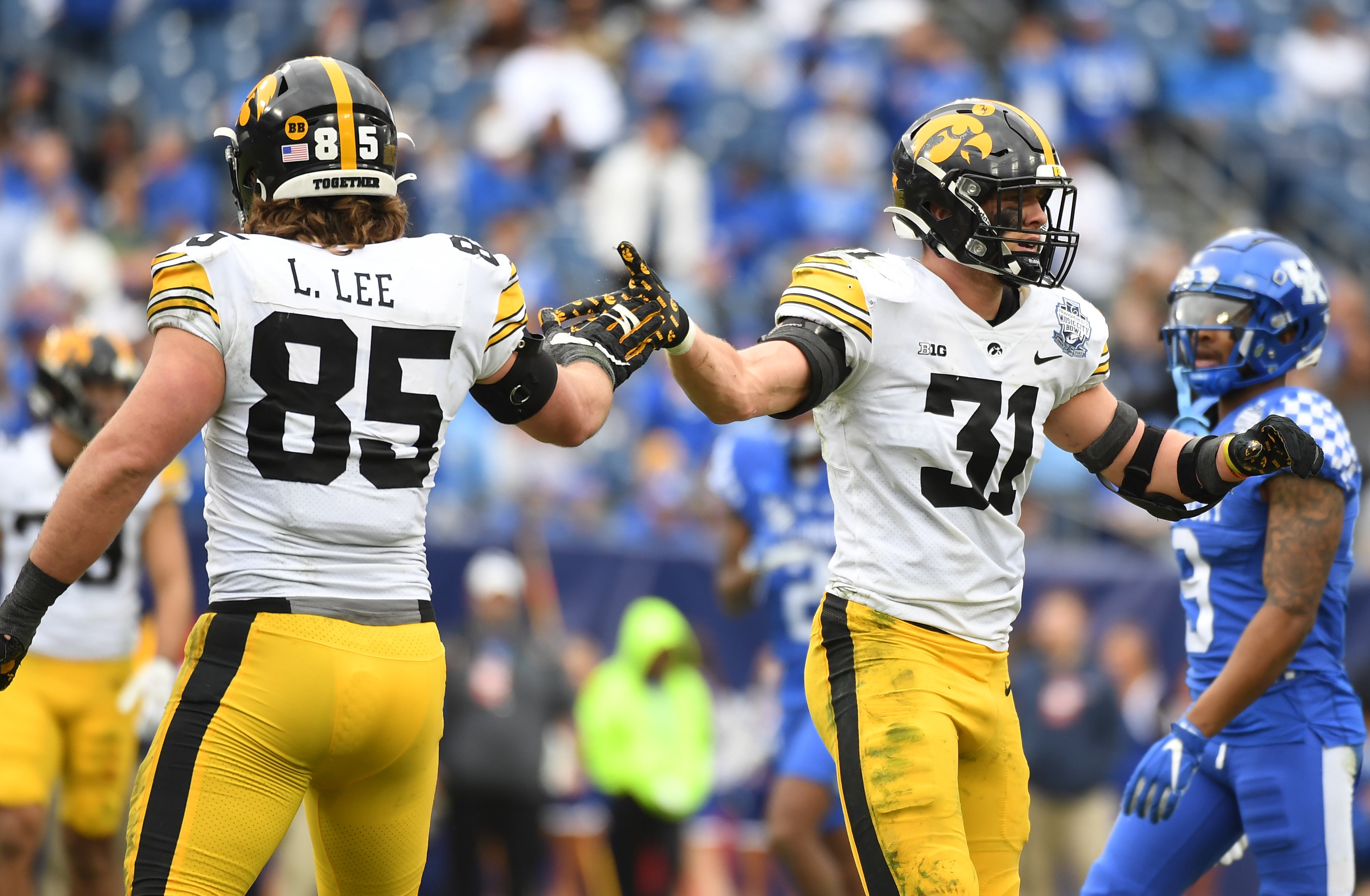 Dec 31, 2022; Nashville, Tennessee, USA; Iowa Hawkeyes linebacker Jack Campbell (31) is congratulated by defensive lineman Logan Lee (85) after a sack during the first half against the Kentucky Wildcats in the 2022 Music City Bowl at Nissan Stadium. Mandatory Credit: Christopher Hanewinckel-USA TODAY Sports  