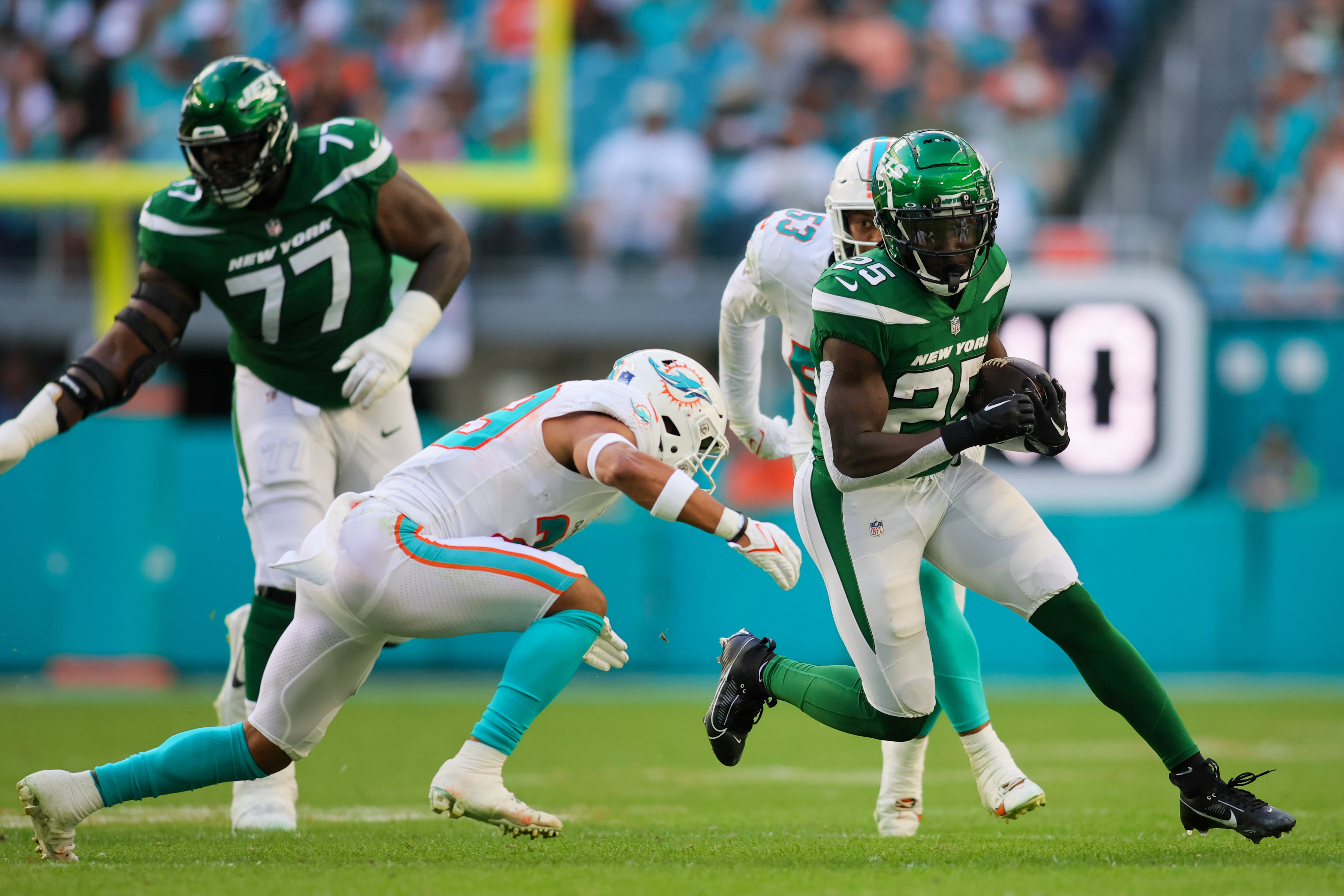 New York Jets running back Israel Abanikanda (25) runs with the football against the Miami Dolphins during the fourth quarter at Hard Rock Stadium.