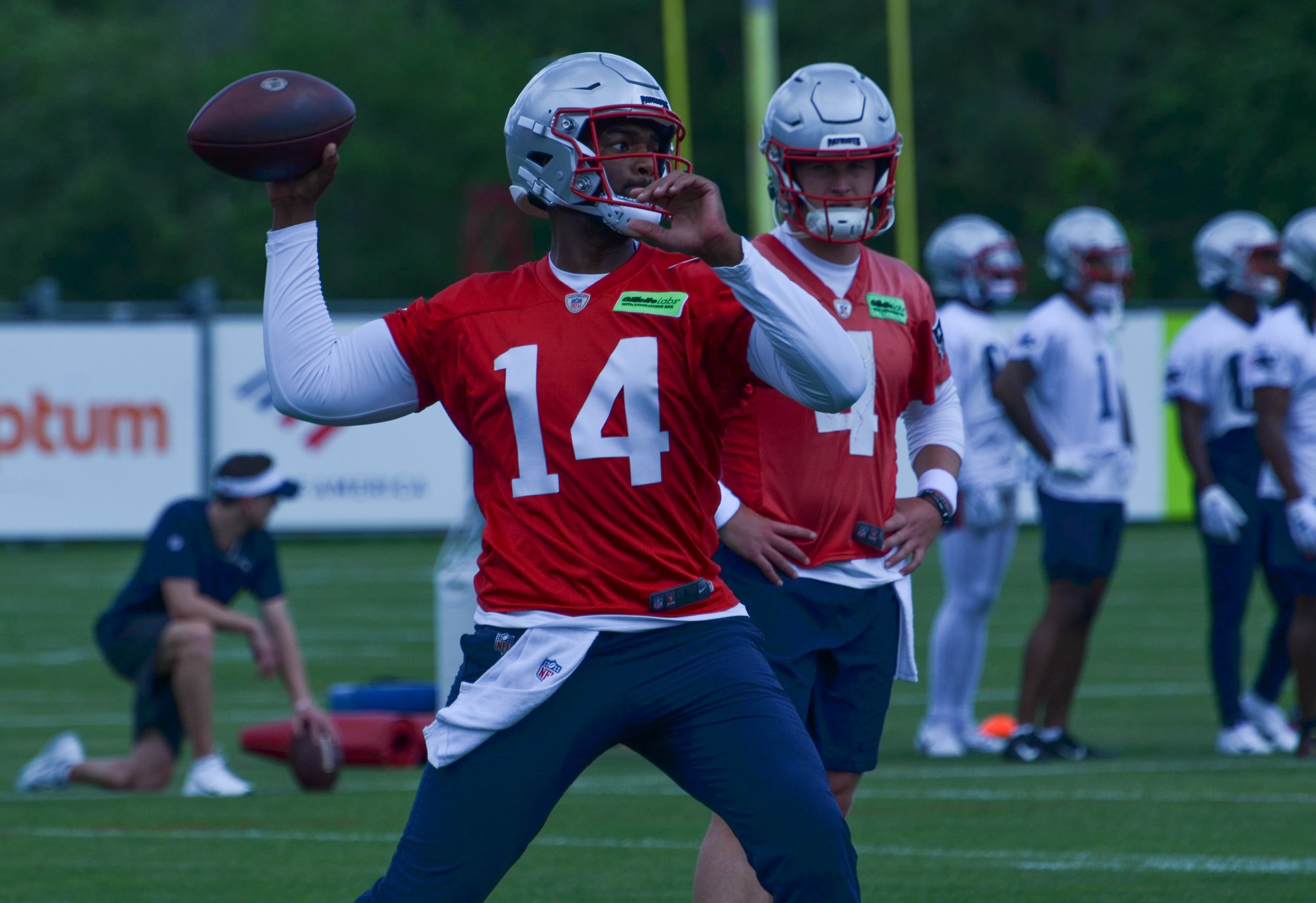 Patriots QB Jacoby Brissett throws the ball as Bailey Zappe looks on at OTAs - May 29, 2024