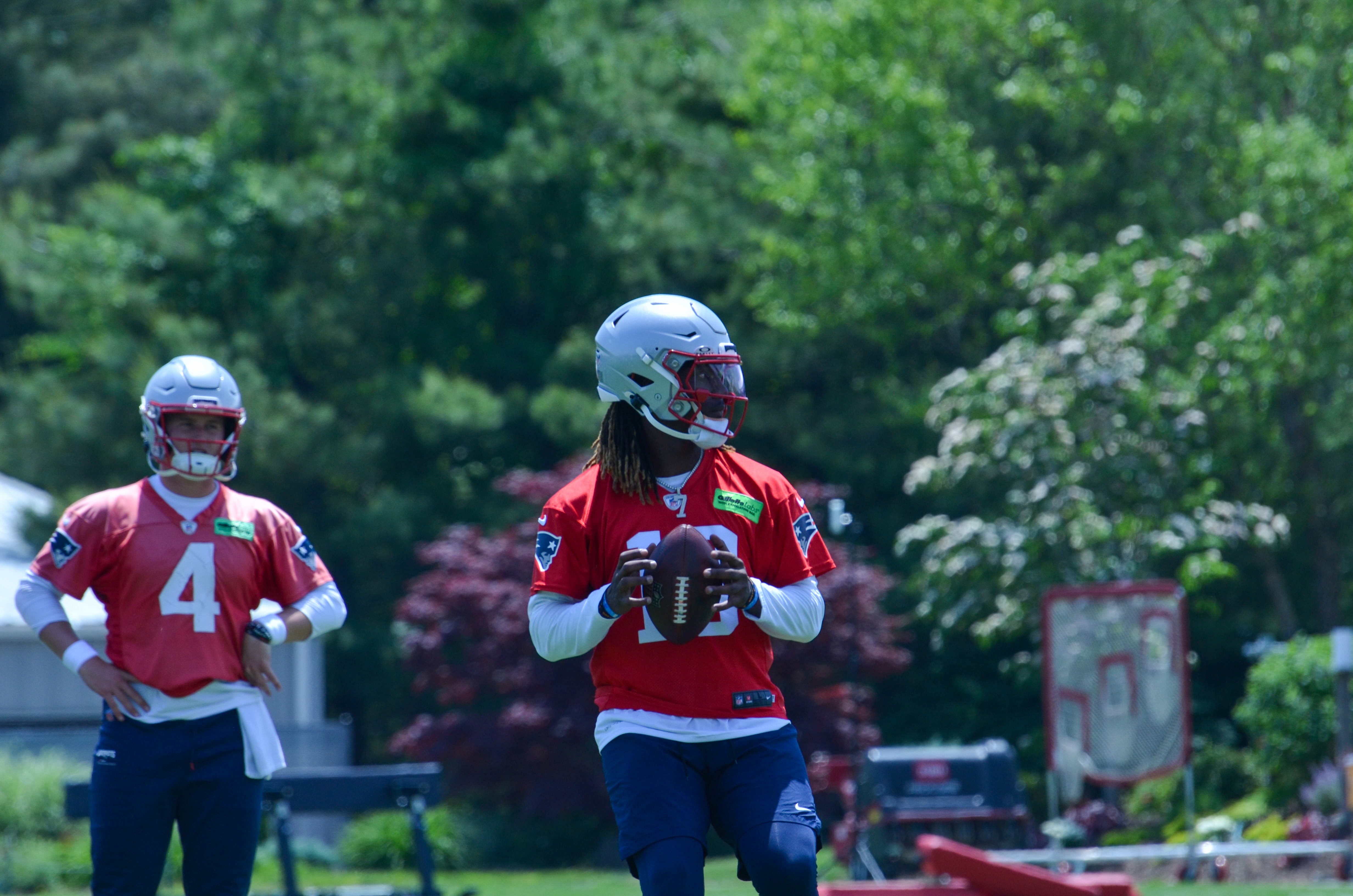 Patriots QB Joe Milton III throws the ball while QB Bailey Zappe watches at Tuesday's OTAs - June 4, 2024