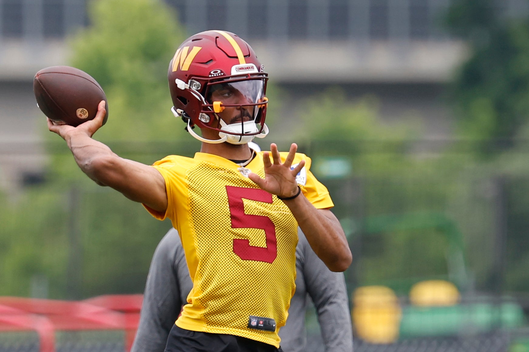 Washington Commanders quarterback Jayden Daniels (5) prepares to pass a ball during an OTA workout at Commanders Park.
