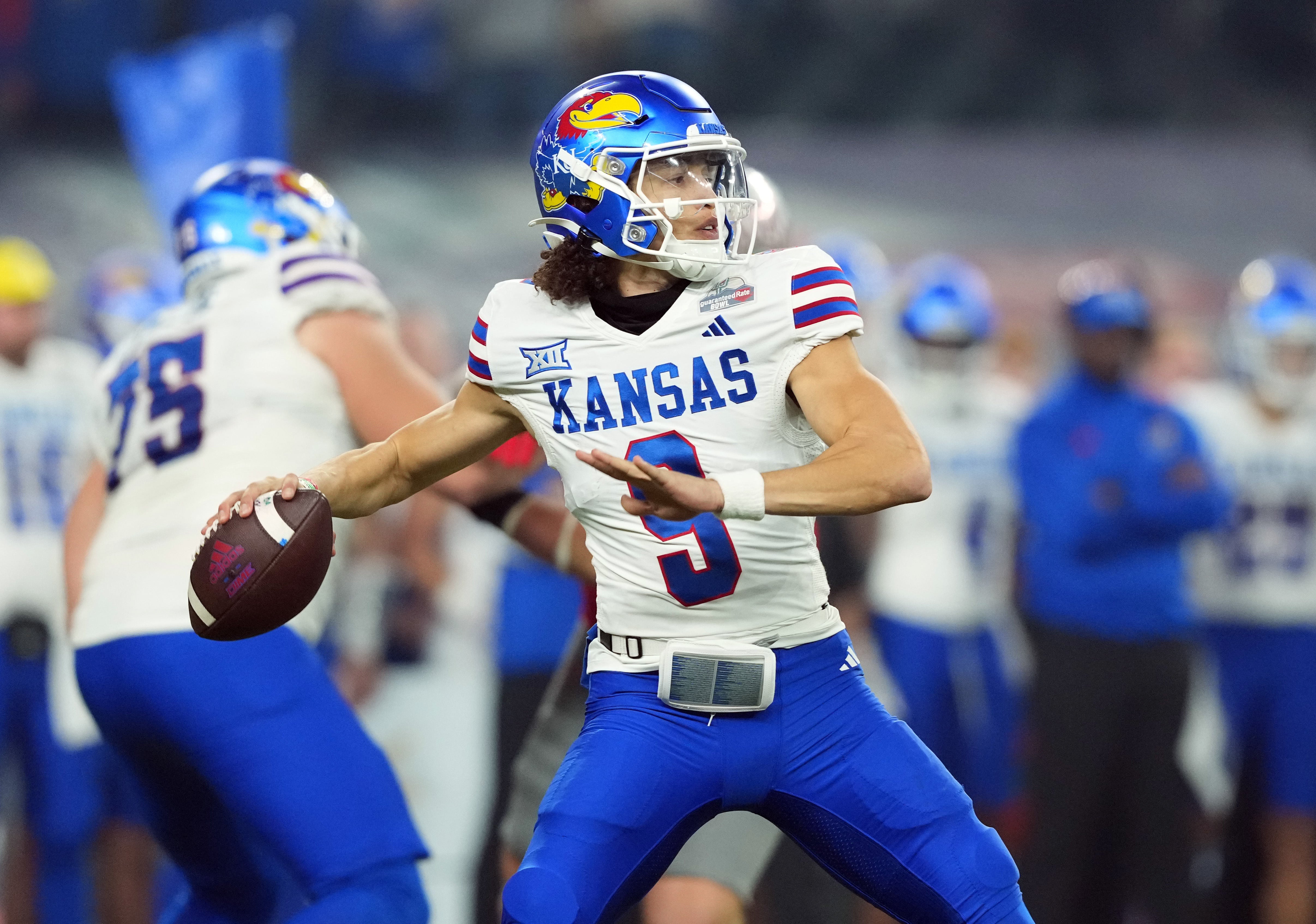Dec 26, 2023; Phoenix, AZ, USA; Kansas Jayhawks quarterback Jason Bean (9) passes against the UNLV Rebels during the first half at Chase Field.