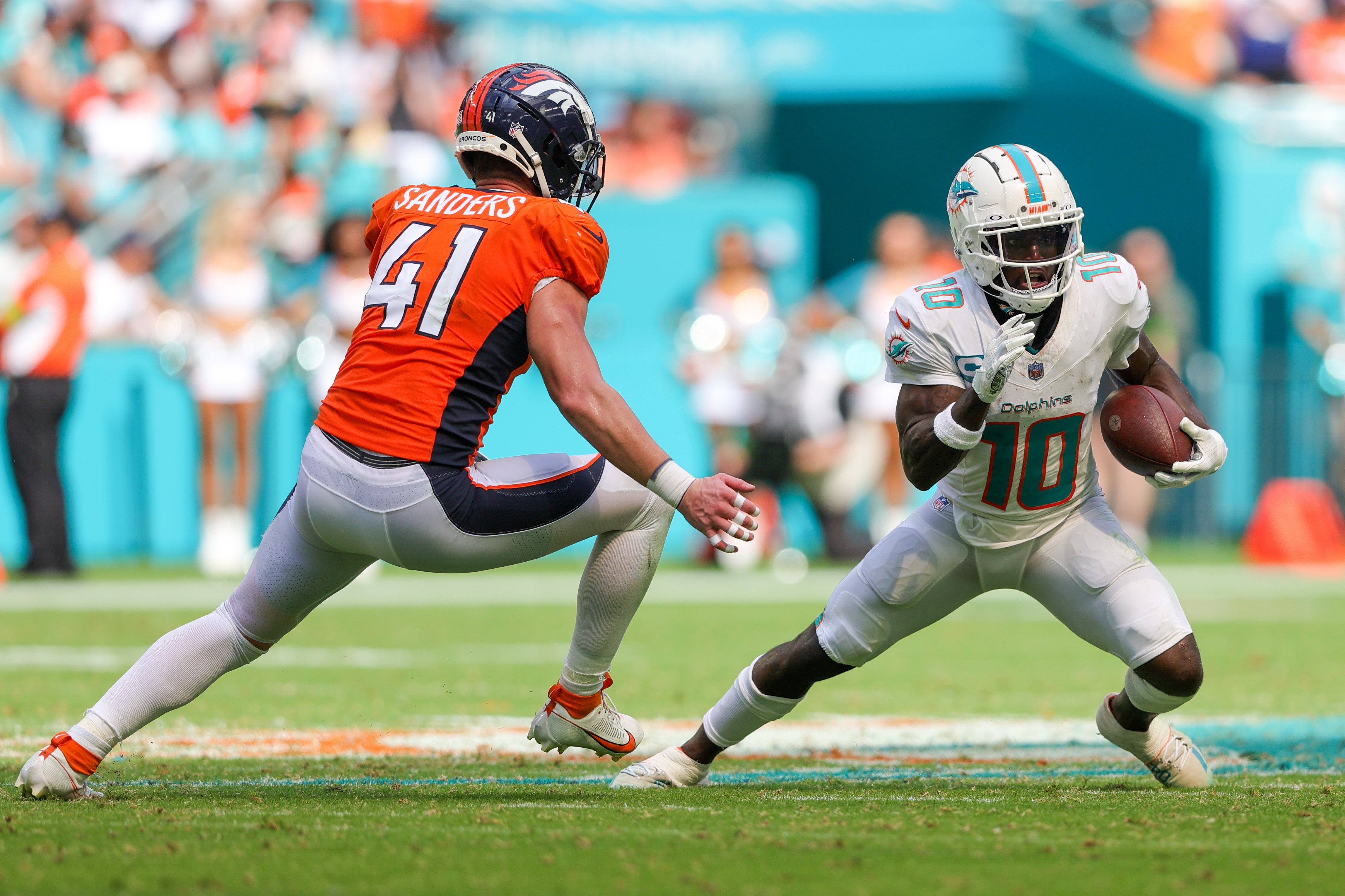 Sep 24, 2023; Miami Gardens, Florida, USA; Miami Dolphins wide receiver Tyreek Hill (10) runs with the ball defended by Denver Broncos linebacker Drew Sanders (41) in the third quarter at Hard Rock Stadium.