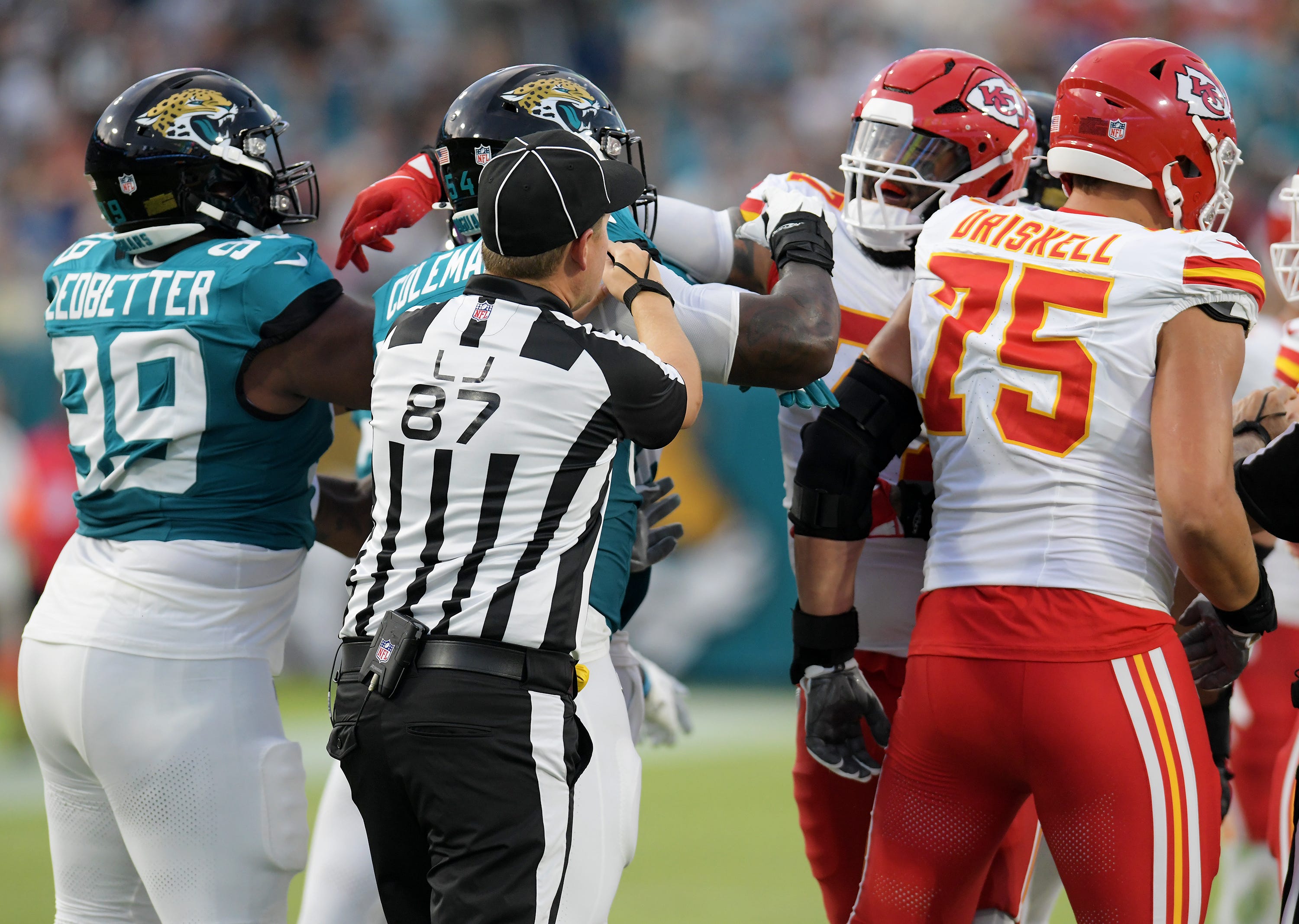 Line judge Tom Eaton (87) tries to break up a scuffle between Jacksonville Jaguars defensive end DJ Coleman (54) and Kansas City Chiefs offensive tackle Lucas Niang (77) after a late hit on Kansas City Chiefs quarterback Carson Wentz (11) after he chased down a bad snap during late second quarter action. The Jaguars led 20 to 10 at the end of the first half. The Jacksonville Jaguars hosted the Kansas City Chiefs in the Jaguars first preseason game of the season Saturday, August10, 2024 at EverBank Stadium i