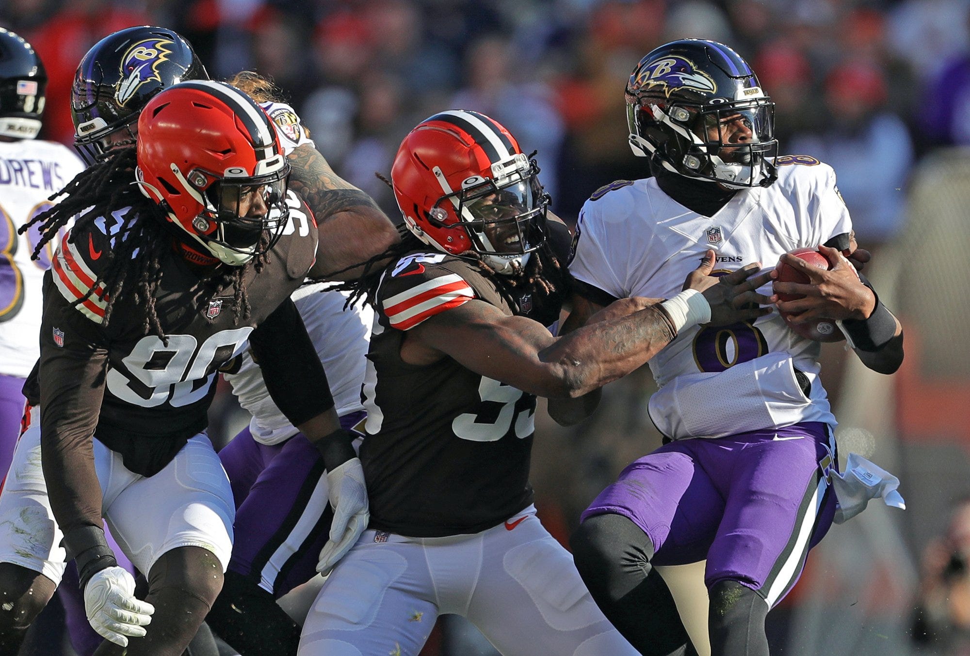 Cleveland Browns defensive end Takkarist McKinley (55) brings down Baltimore Ravens quarterback Lamar Jackson (8) during the first half of an NFL football game at FirstEnergy Stadium, Sunday, Dec. 12, 2021, in Cleveland, Ohio.