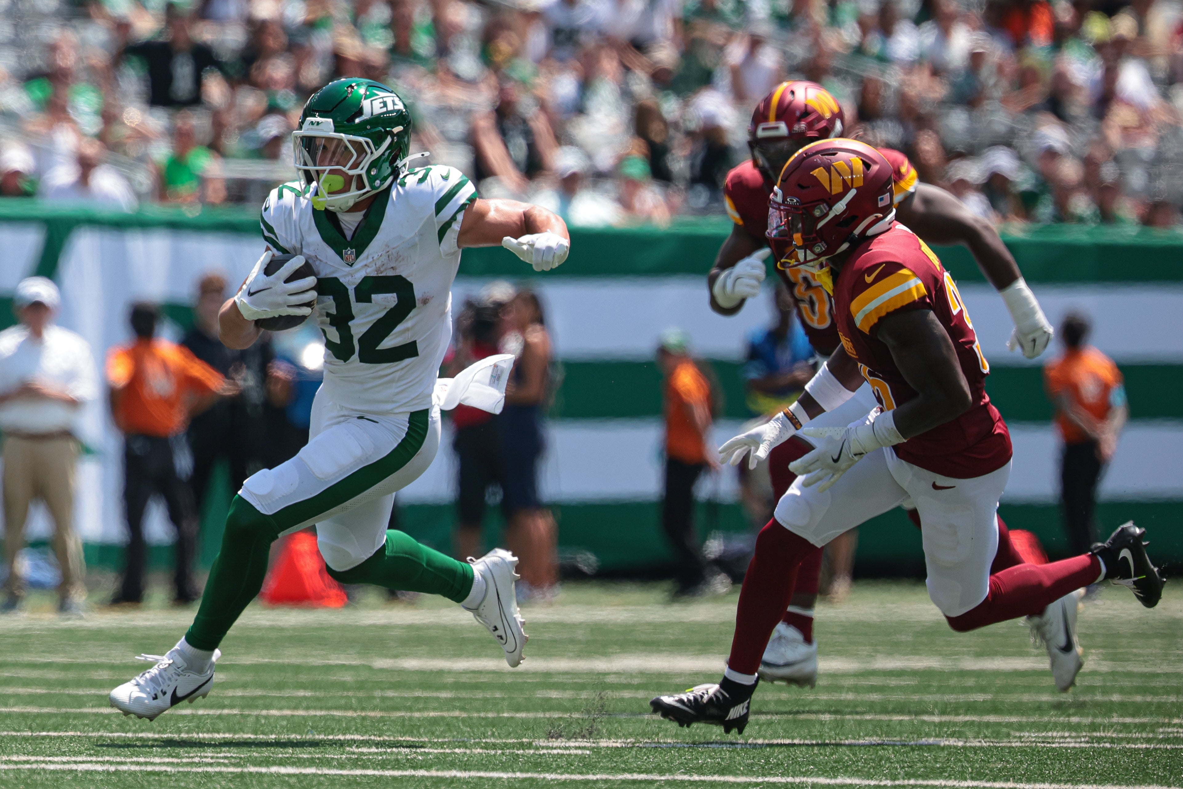 New York Jets running back Isaiah Davis (32) carries the ball as Washington Commanders cornerback Benjamin St-Juste (25) pursues during the game at MetLife Stadium.
