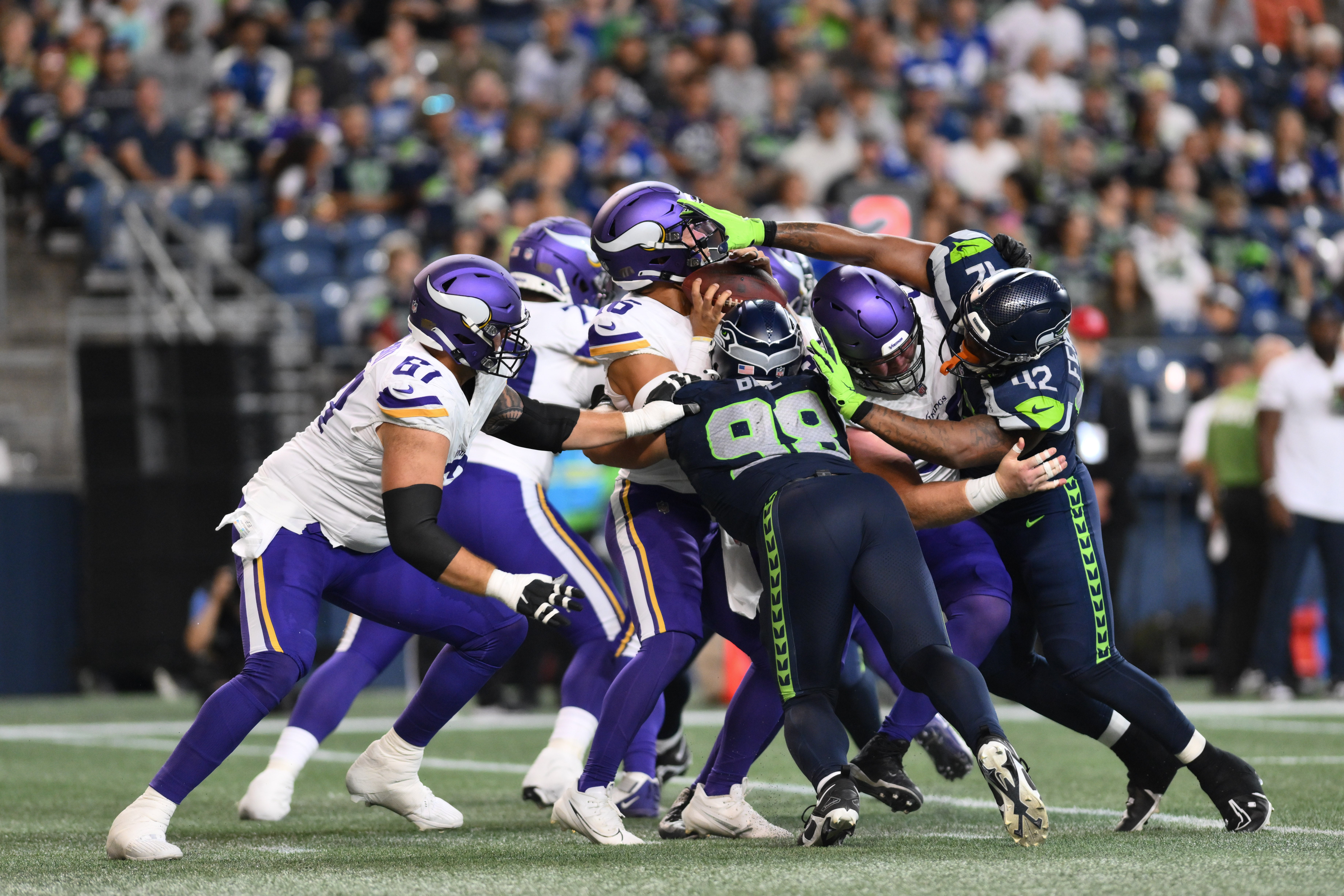 Aug 10, 2023; Seattle, Washington, USA; Minnesota Vikings quarterback Jaren Hall (16) is tackled by Seattle Seahawks linebacker Levi Bell (98) and defensive end Jordan Ferguson (42) during the second half at Lumen Field.