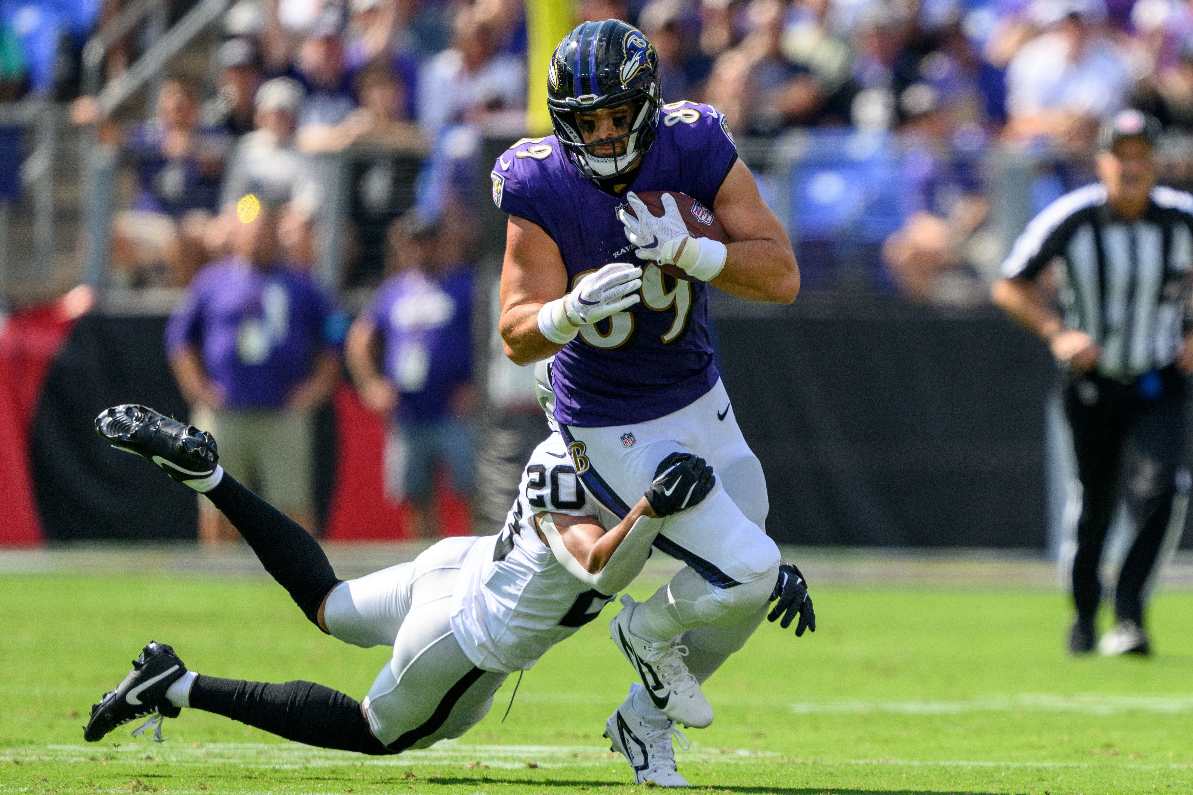 Sep 15, 2024; Baltimore, Maryland, USA; Baltimore Ravens tight end Mark Andrews (89) runs with the ball as Las Vegas Raiders safety Isaiah Pola-Mao (20) attempts to make a tackle during the first half at M&T Bank Stadium.