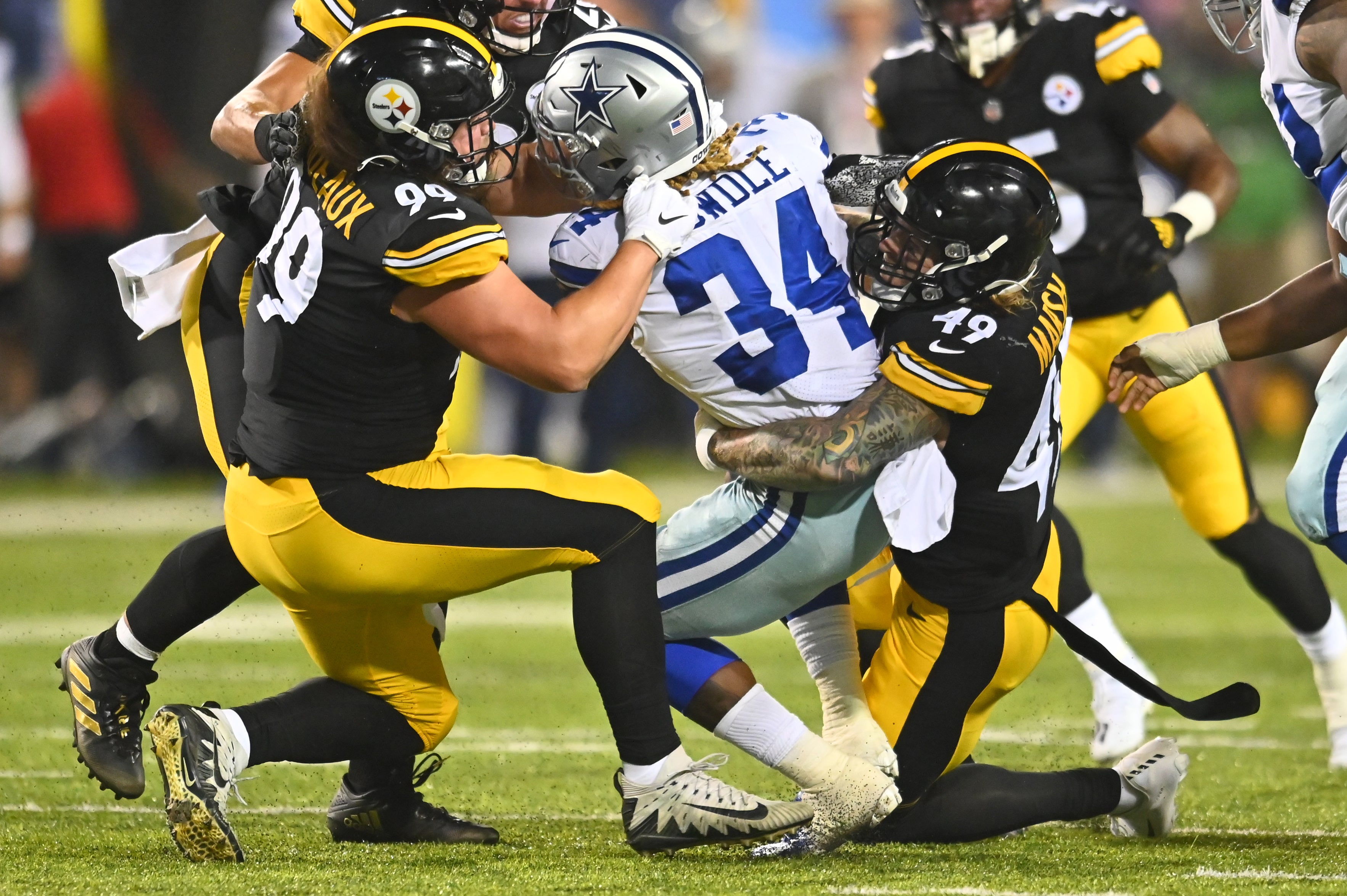 Aug 5, 2021; Canton, Ohio, USA; Pittsburgh Steelers defensive tackle Henry Mondeaux (99) and defensive end Cassius Marsh (49) tackle Dallas Cowboys running back Rico Dowdle (34) during the first half at Tom Benson Hall of Fame Stadium.