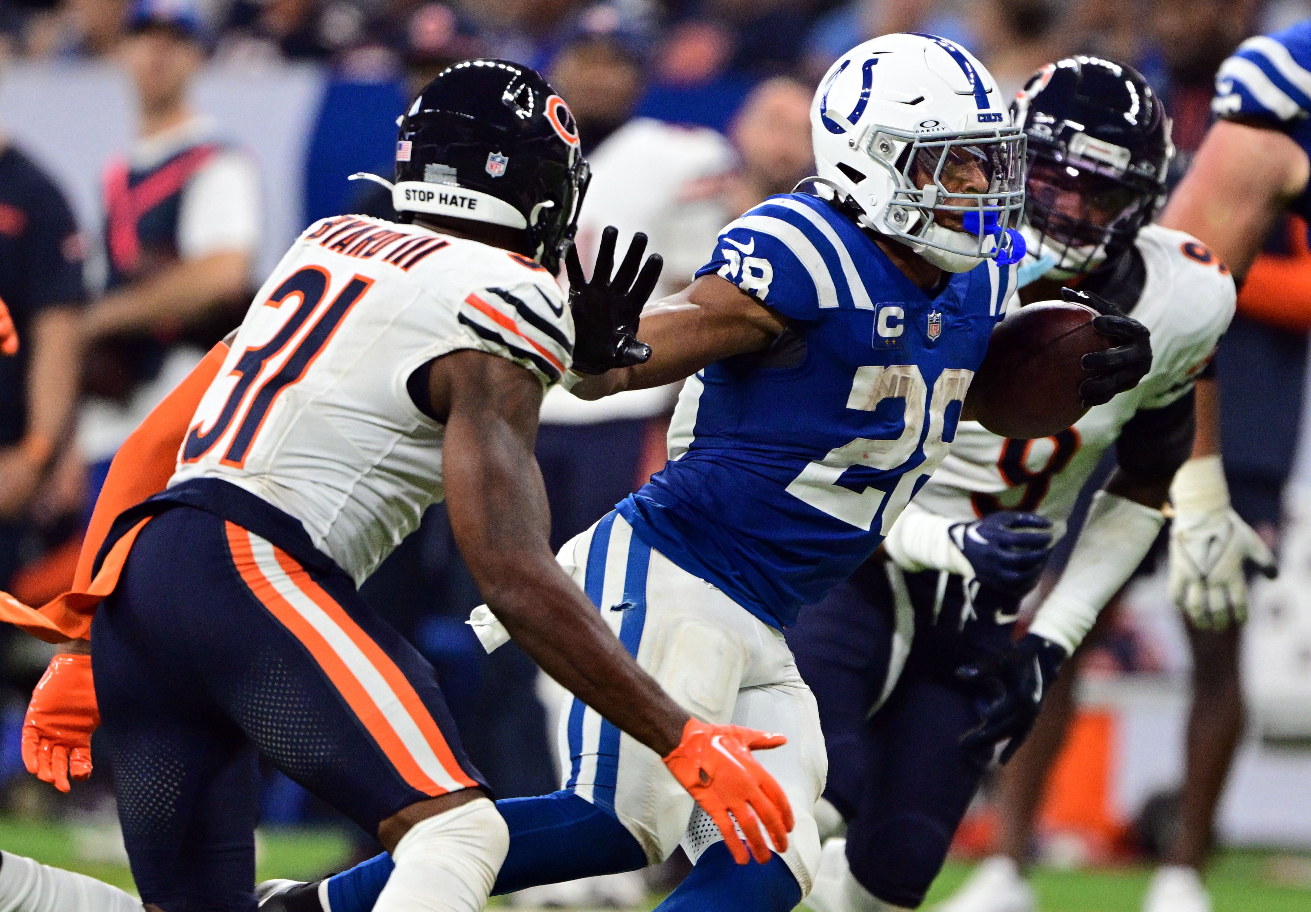 Sep 22, 2024; Indianapolis, Indiana, USA; Indianapolis Colts running back Jonathan Taylor (28) holds his arm out to block coverage from Chicago Bears safety Kevin Byard III (31) during the second half at Lucas Oil Stadium.
