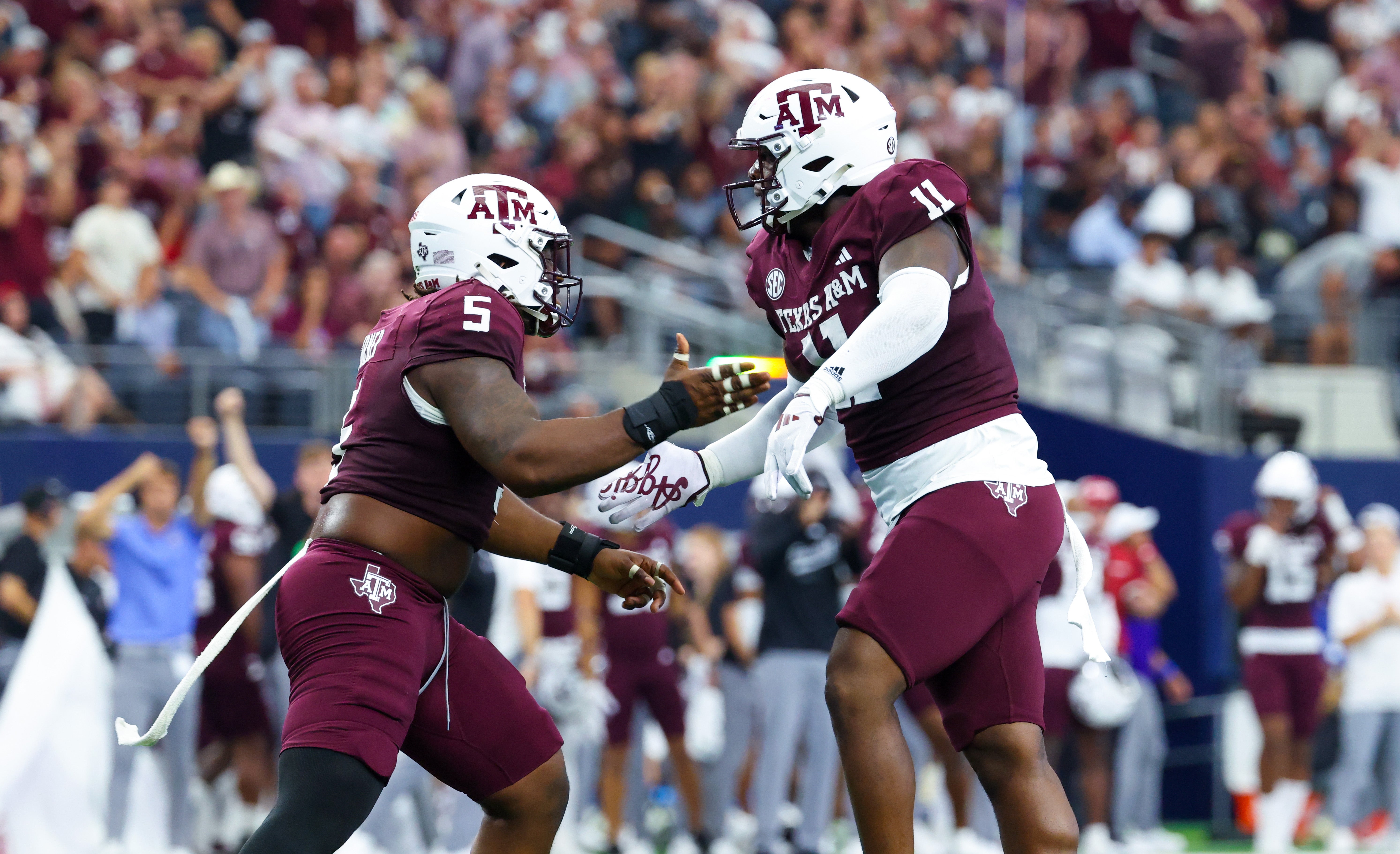 Texas A&M Aggies defensive lineman Nic Scourton (11) celebrates with Texas A&M Aggies defensive lineman Shemar Turner (5) during the first half against the Arkansas Razorbacks at AT&T Stadium.