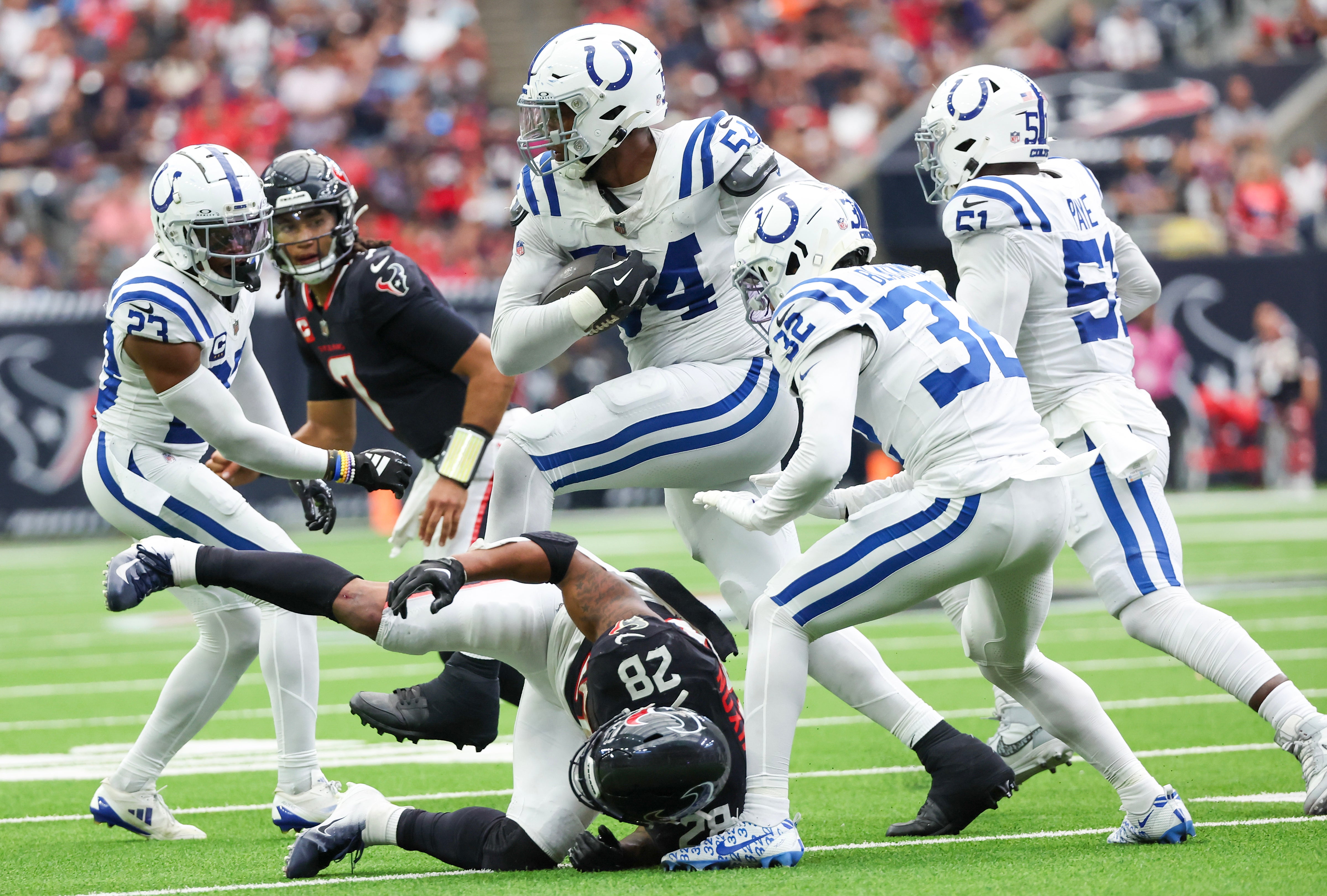 Oct 27, 2024; Houston, Texas, USA; Indianapolis Colts defensive end Dayo Odeyingbo (54) picks up a fumble and hurdles Houston Texans running back Joe Mixon (28) in the second half at NRG Stadium.