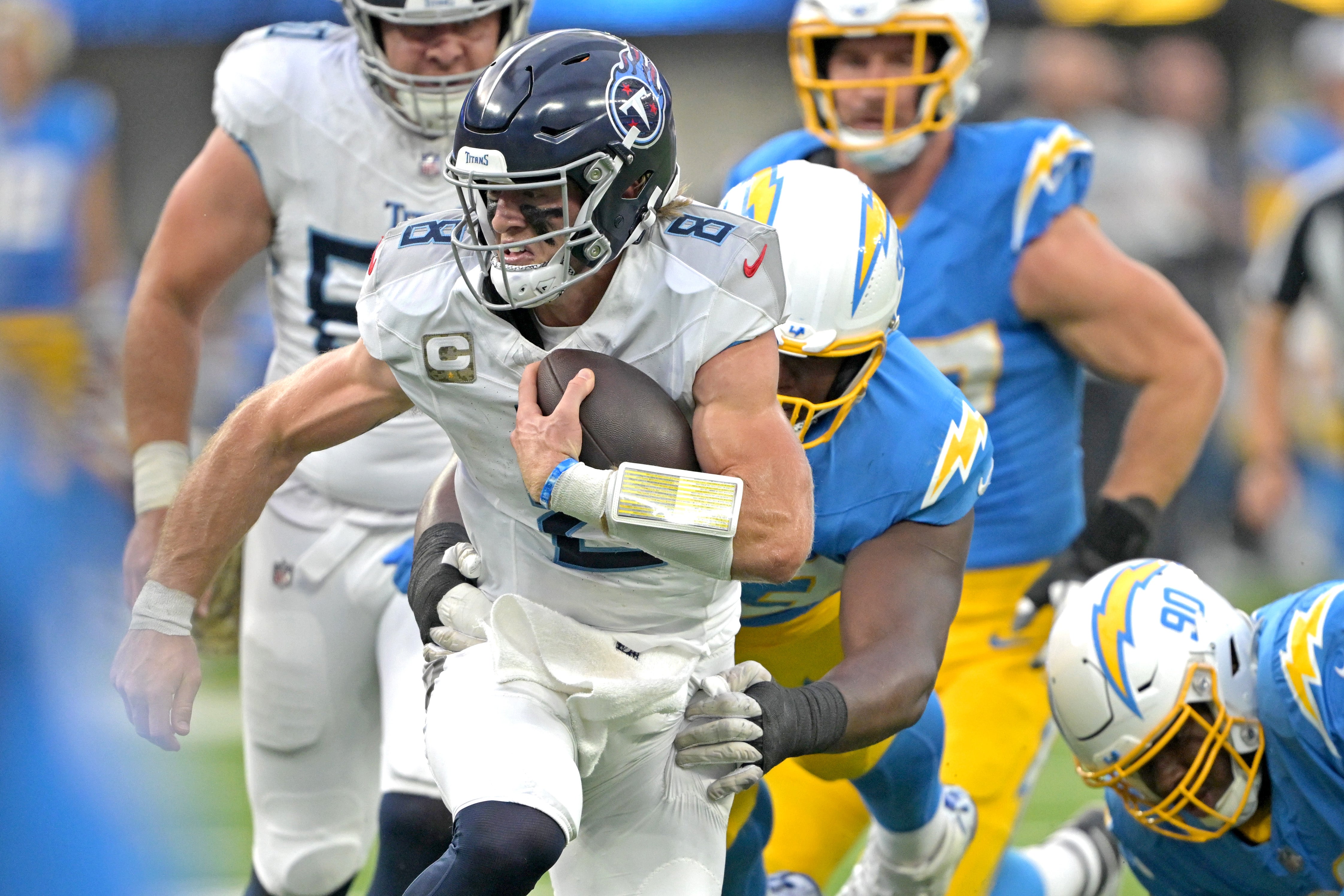 Nov 10, 2024; Inglewood, California, USA; Tennessee Titans quarterback Will Levis (8) gets past Los Angeles Chargers defensive tackle Otito Ogbonnia (93) and defensive tackle Teair Tart (90) for a first down in the second half at SoFi Stadium. Mandatory Credit: Jayne Kamin-Oncea-Imagn Images