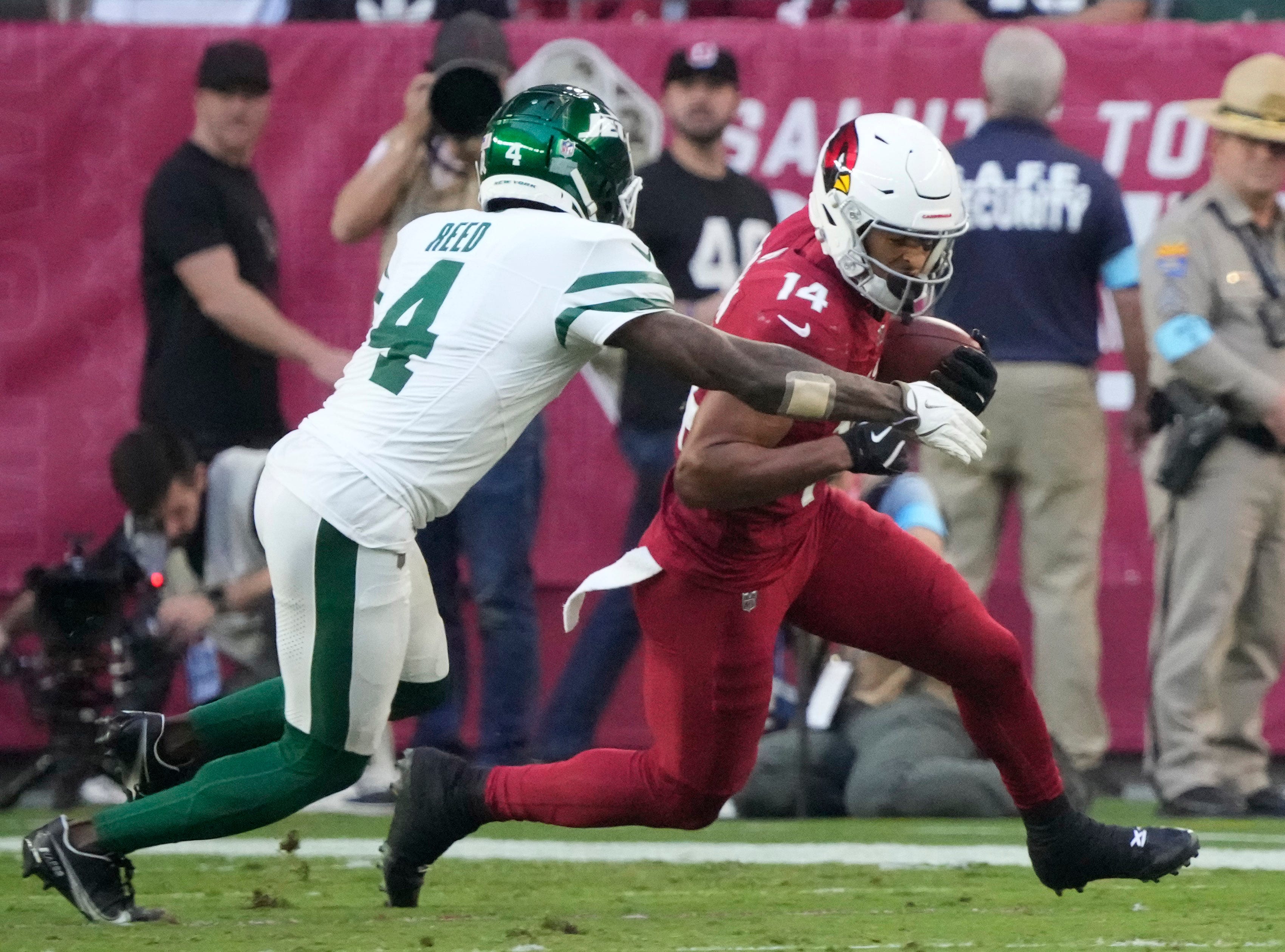 Arizona Cardinals wide receiver Michael Wilson (14) is tackled by New York Jets cornerback D.J. Reed (4) after a catch during the third quarter at State Farm Stadium in Glendale on Nov. 10, 2024.