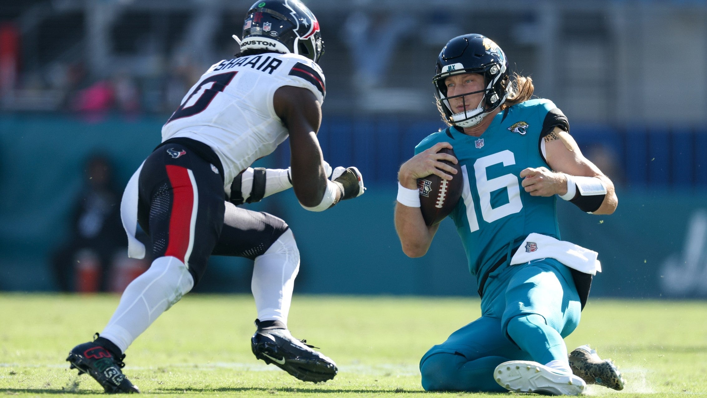 Dec 1, 2024; Jacksonville, Florida, USA; Jacksonville Jaguars quarterback Trevor Lawrence (16) slides down in front of Houston Texans linebacker Azeez Al-Shaair (0) in the second quarter in the second quarter at EverBank Stadium.