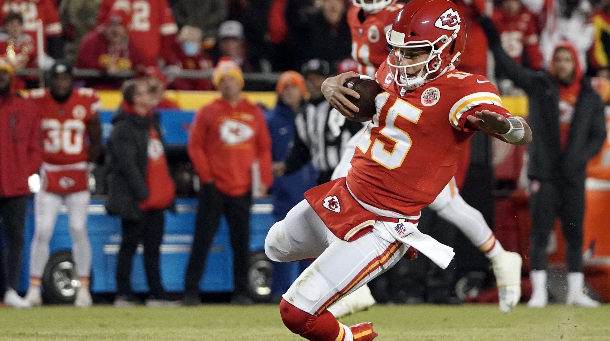Jan 23, 2022; Kansas City, Missouri, USA; Kansas City Chiefs quarterback Patrick Mahomes (15) slides as he scrambles out of the pocket against the Buffalo Bills during the first quarter in the AFC Divisional playoff football game at GEHA Field at Arrowhead Stadium.