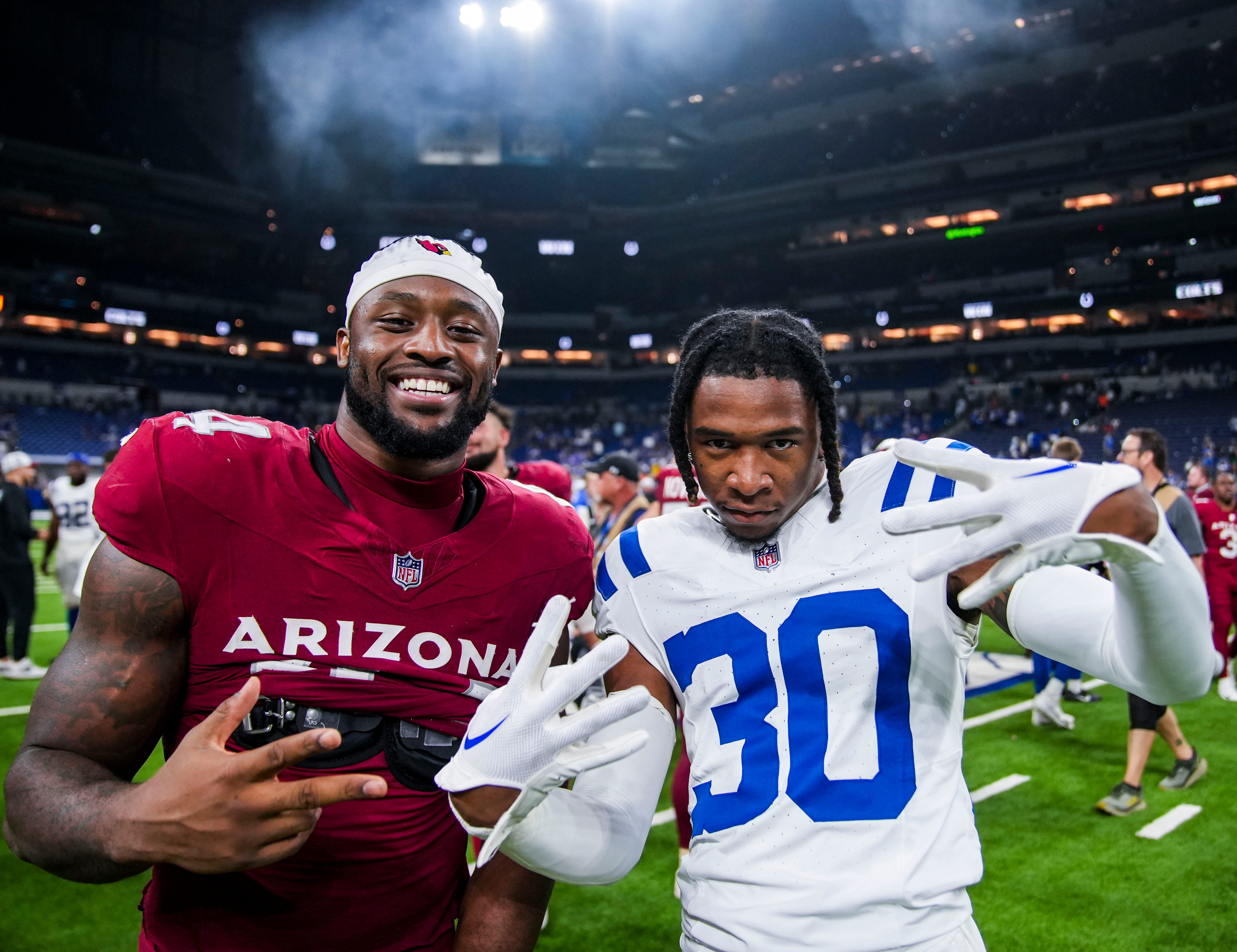 Arizona Cardinals inside linebacker Owen Pappoe (44) and Indianapolis Colts defensive back Jaylin Simpson (30) pose for a photo Saturday, Aug. 17, 2024, after a preseason game between the Indianapolis Colts and the Arizona Cardinals at Lucas Oil Stadium in Indianapolis. The Colts defeated the Cardinals, 21-13.