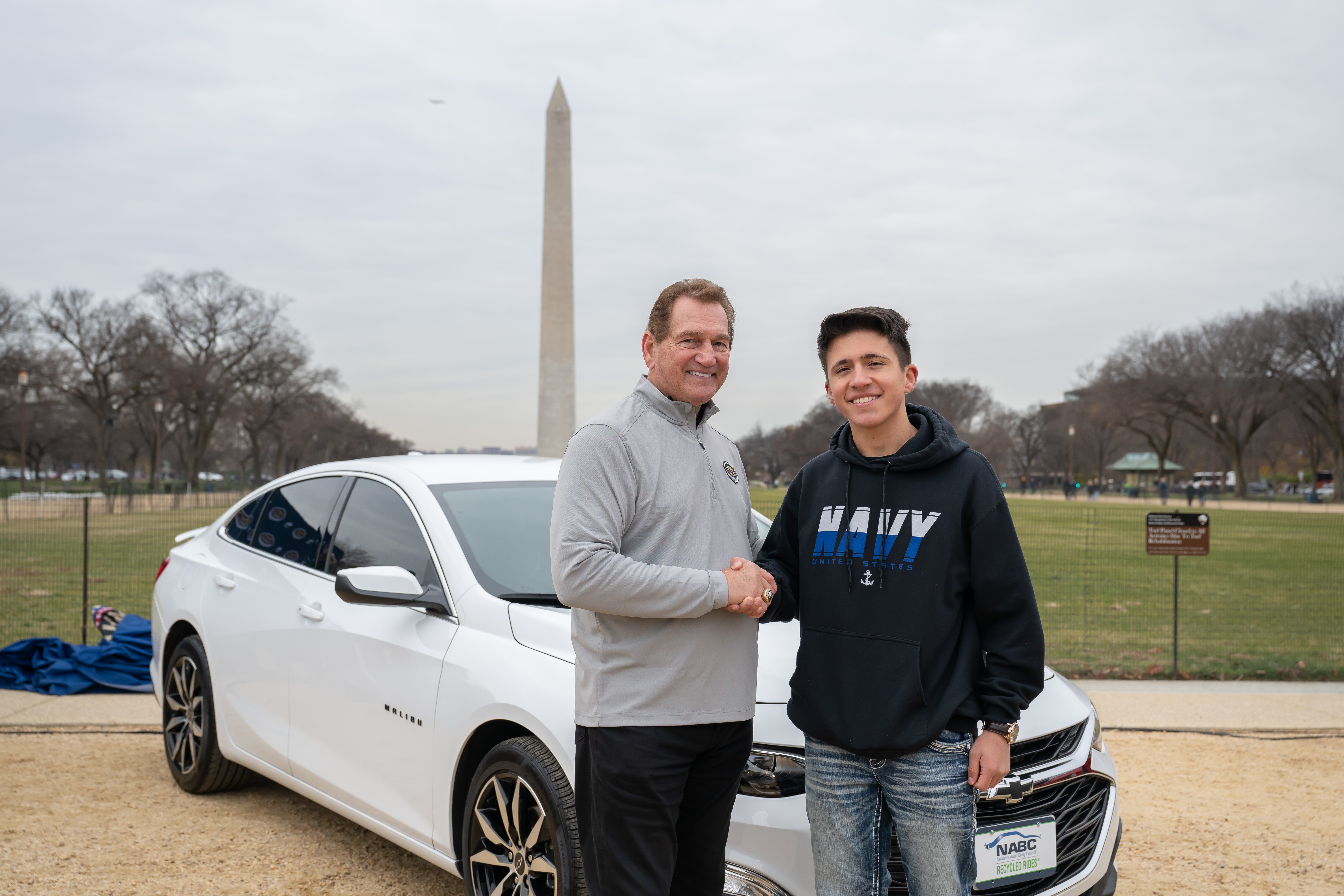 NFL legend Joe Theismann (left) poses with U.S. Navy Seaman Matthew Walker who was gifted a vehicle by USAA at USAA’s Army-Navy Game NABC Recycled Rides Car Gifting event in Washington on Friday, December 13th, 2024. The event was held to showcase USAA’s commitment to serving the military community and the spirit of ‘America’s Game.’