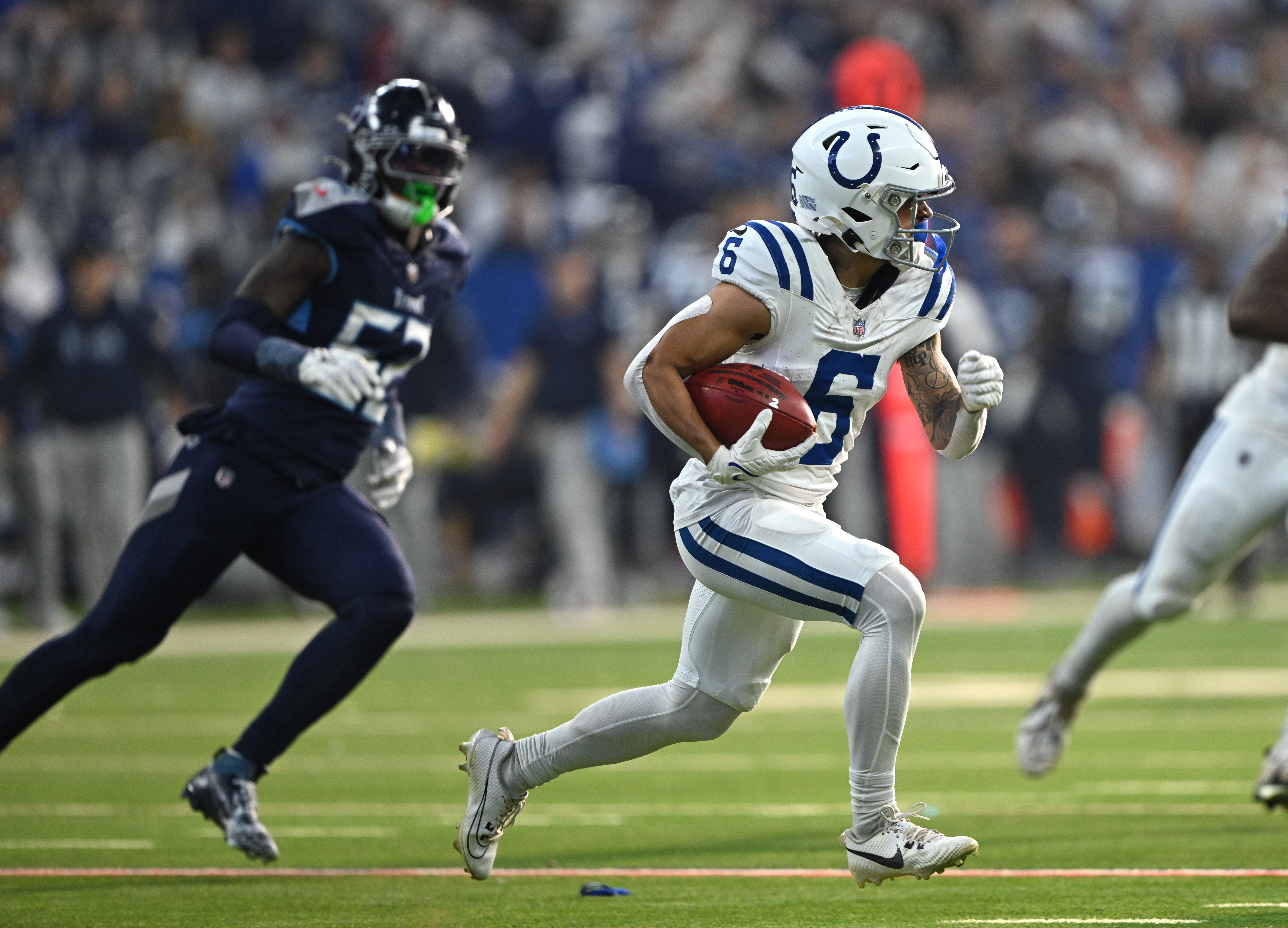 Dec 22, 2024; Indianapolis, Indiana, USA; Indianapolis Colts wide receiver Anthony Gould (6) runs the ball back from a kickoff in front of Tennessee Titans linebacker James Williams (52) during the second half at Lucas Oil Stadium.