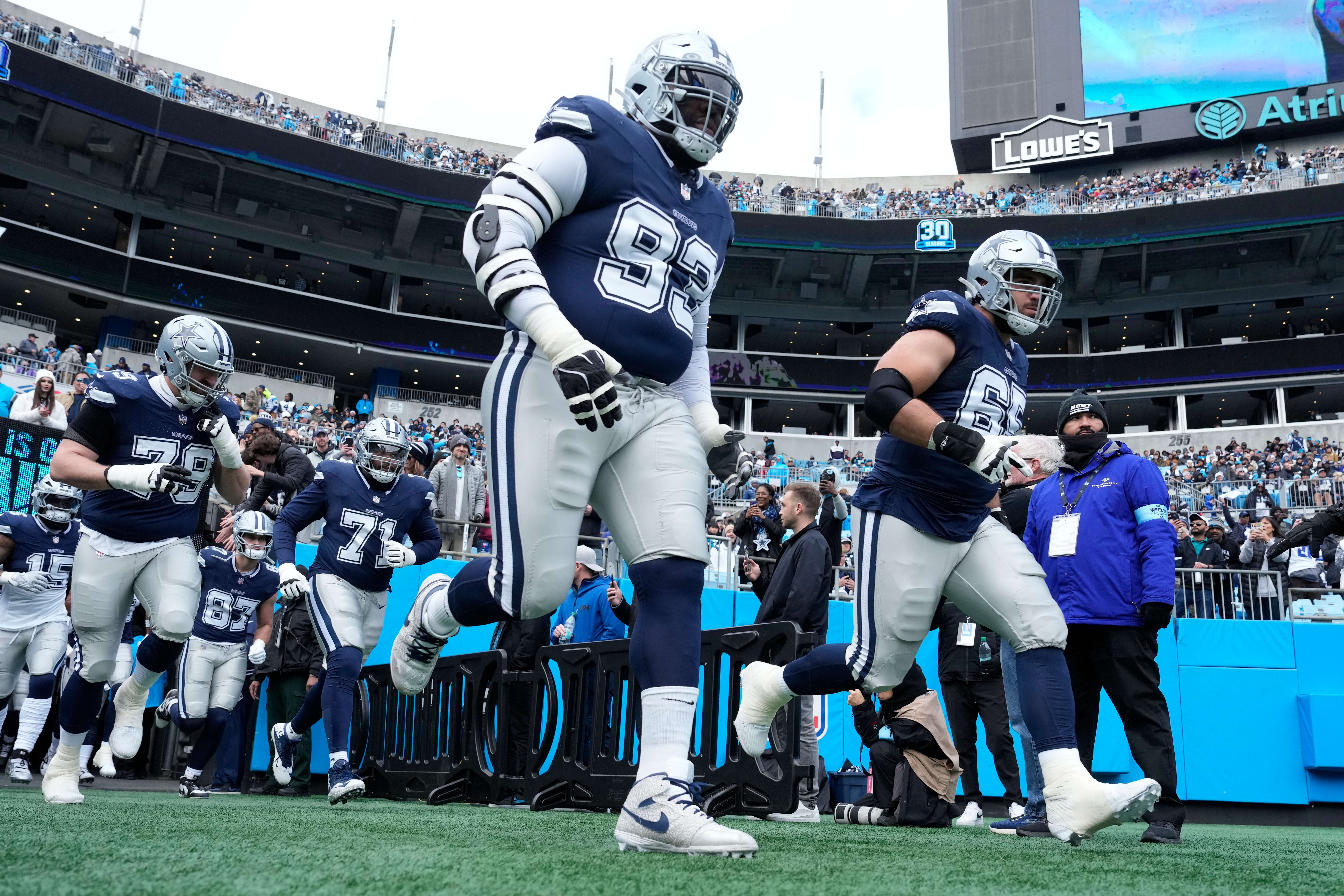 Dallas Cowboys including defensive tackle Linval Joseph (93) and offensive tackle Dakoda Shepley (65) run on to the field before the game at Bank of America Stadium.