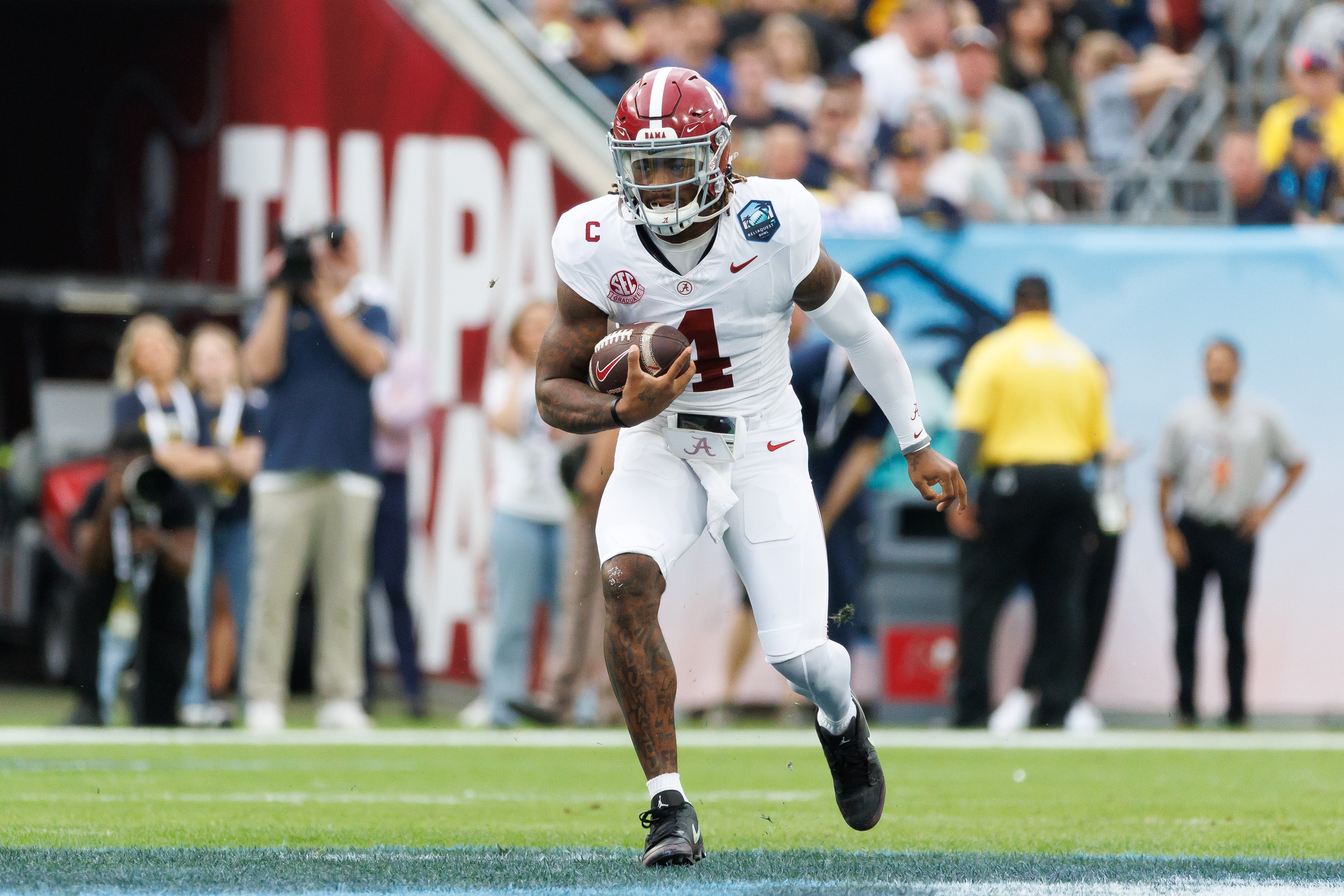 Dec 31, 2024; Tampa, FL, USA; Alabama Crimson Tide quarterback Jalen Milroe (4) runs with the ball against the Michigan Wolverines during the first half at Raymond James Stadium.