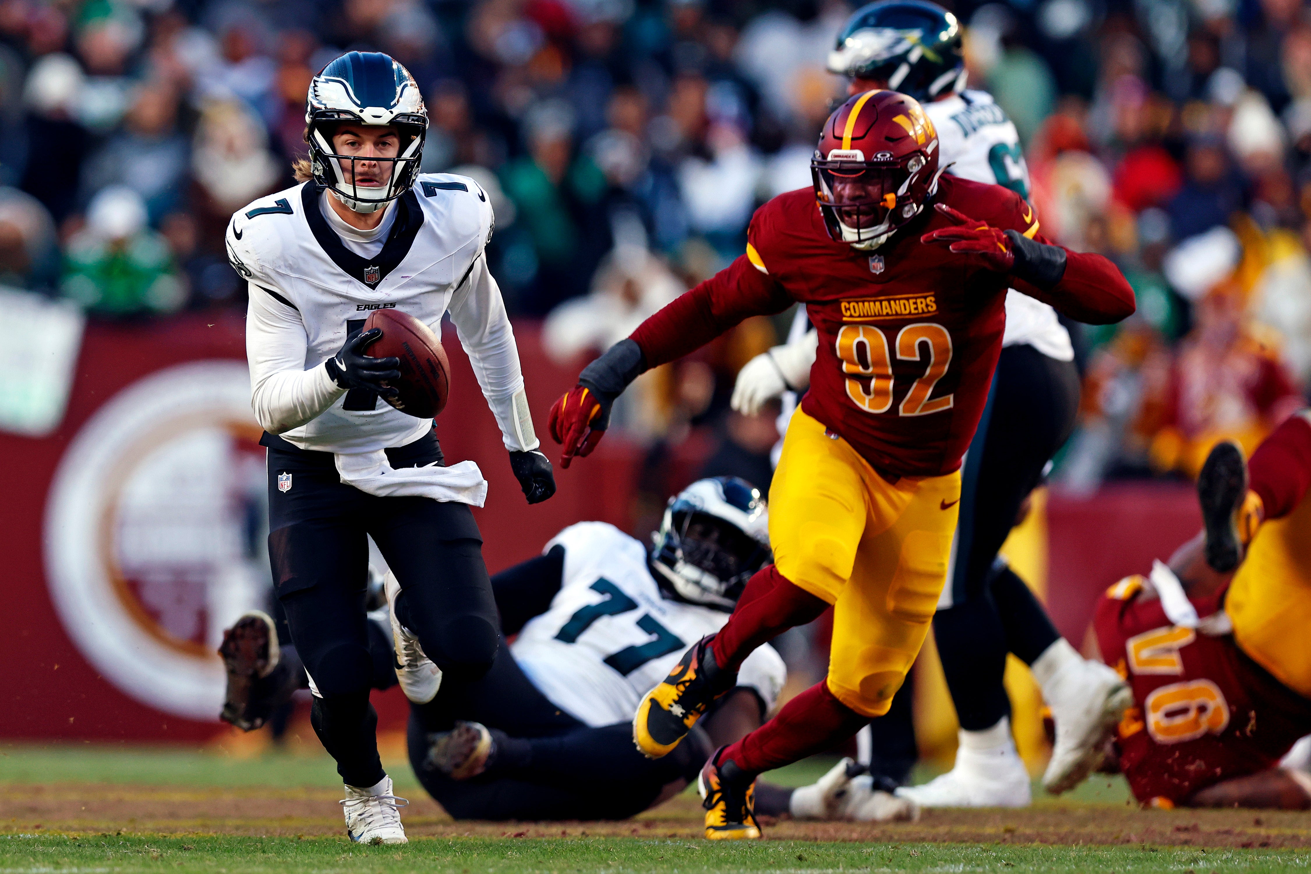 Dec 22, 2024; Landover, Maryland, USA; Philadelphia Eagles quarterback Kenny Pickett (7) runs the ball against Washington Commanders defensive end Dorance Armstrong (92) during the third quarter at Northwest Stadium.