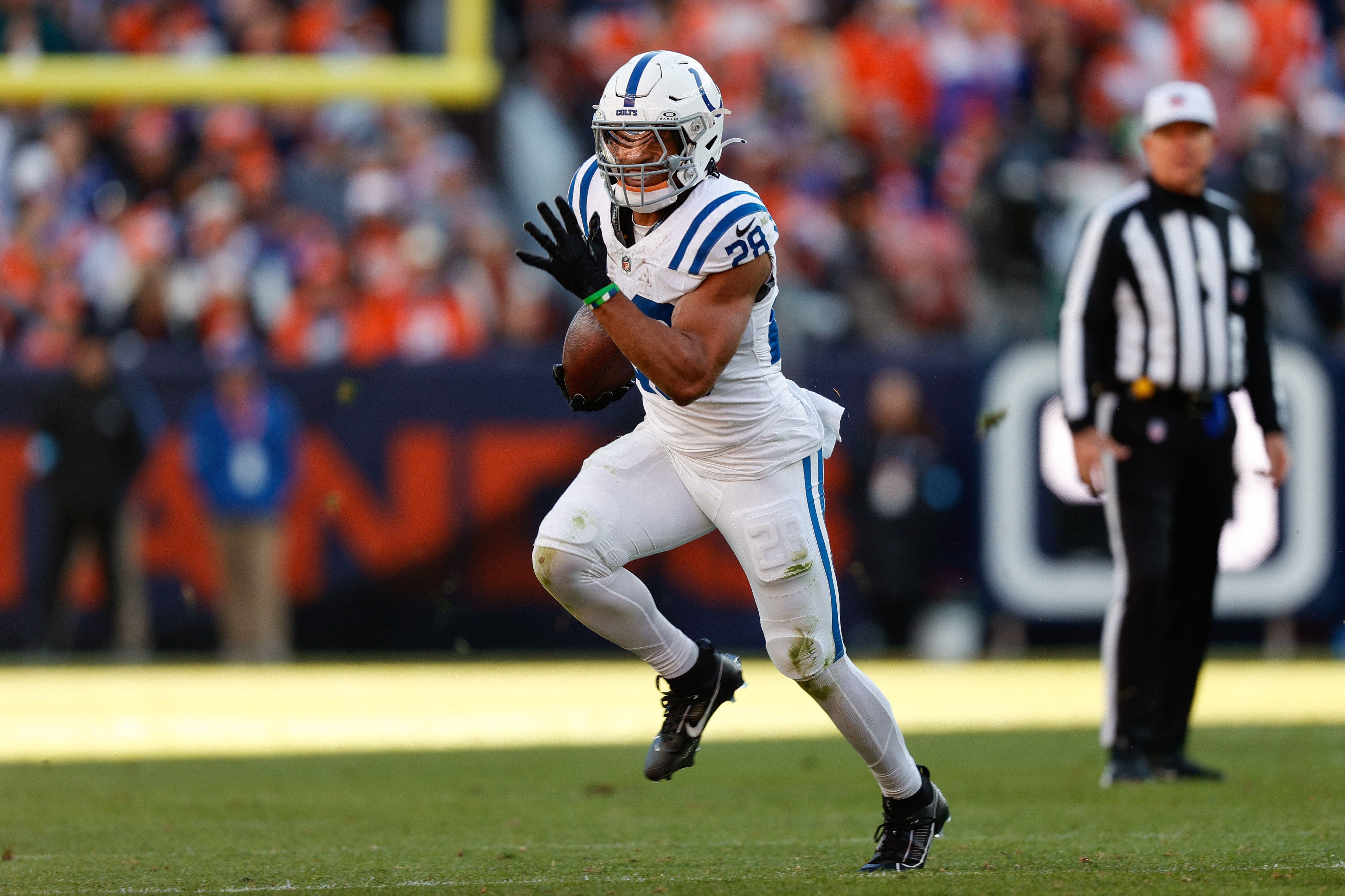 Dec 15, 2024; Denver, Colorado, USA; Indianapolis Colts running back Jonathan Taylor (28) runs the ball in the first quarter against the Denver Broncos at Empower Field at Mile High.