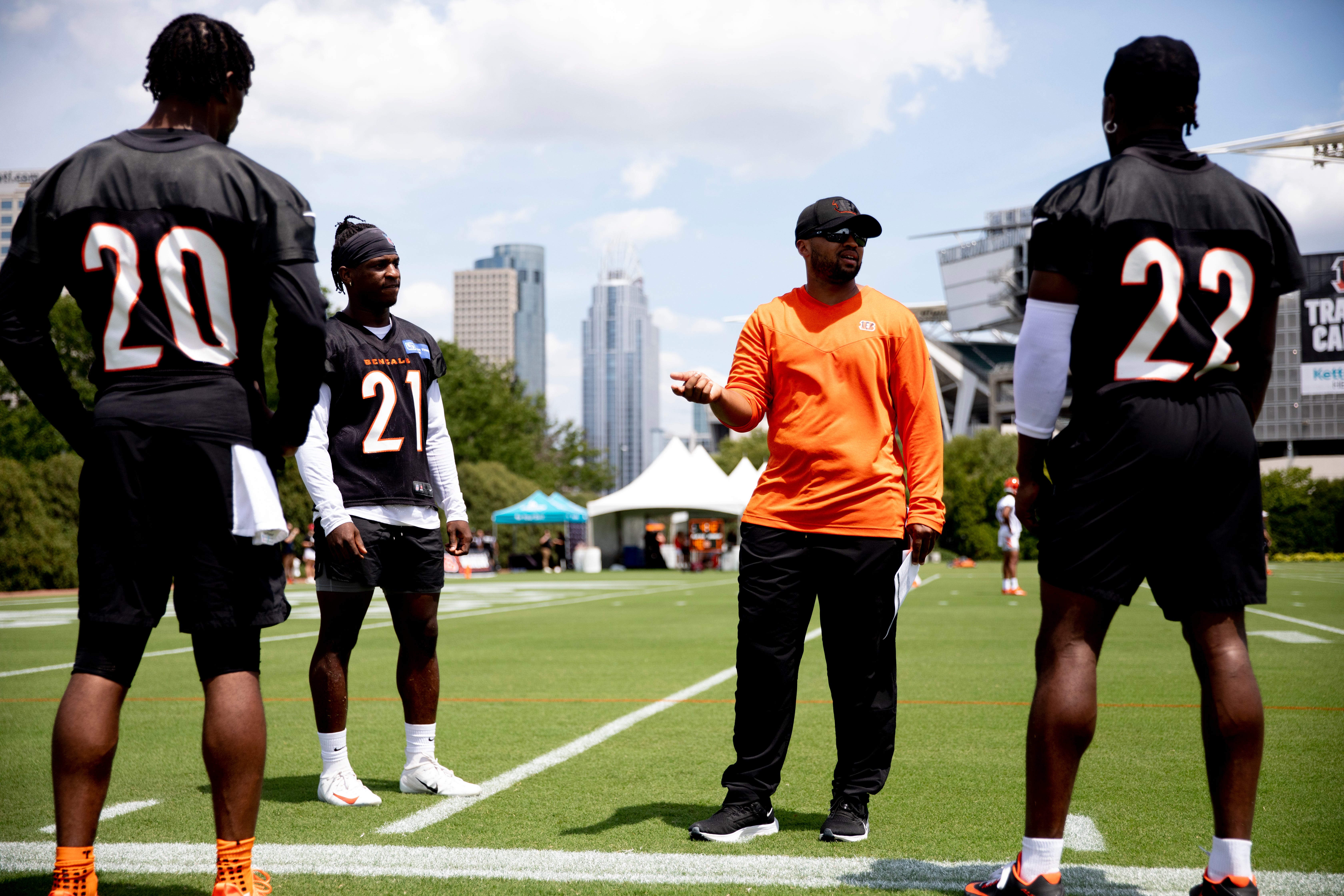 Cincinnati Bengals cornerback Mike Hilton (21), Cincinnati Bengals cornerback Eli Apple (20) and Cincinnati Bengals cornerback Chidobe Awuzie (22) listen to Cincinnati Bengals cornerbacks coach Charles Burks during Cincinnati Bengals preseason training camp at the Paul Brown Stadium training facility in Cincinnati on Thursday, July 28, 2022. Cincinnati Bengals Training Camp