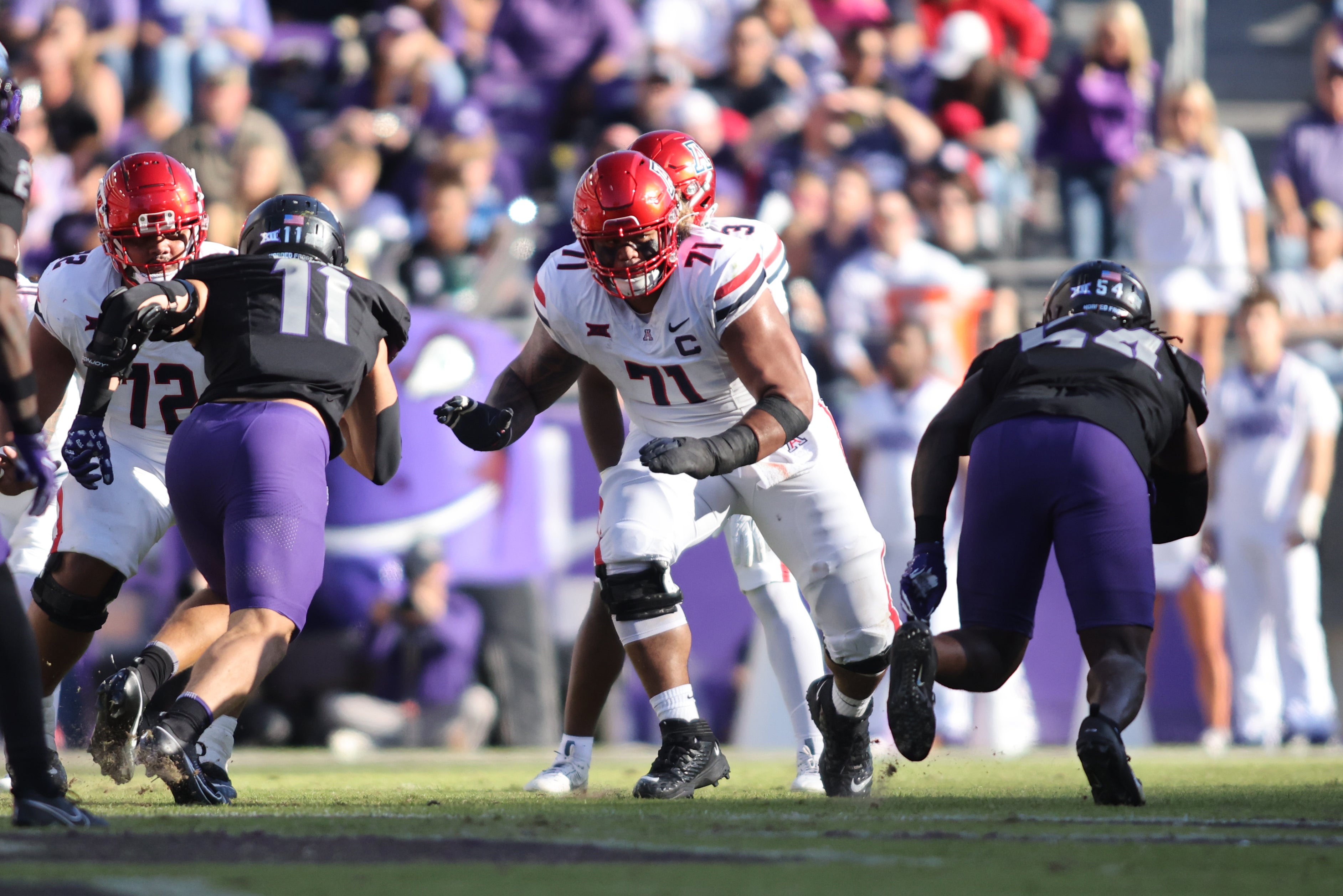 Nov 23, 2024; Fort Worth, Texas, USA; Arizona Wildcats offensive lineman Jonah Savaiinaea (71) blocks in the second quarter against the TCU Horned Frogs at Amon G. Carter Stadium.