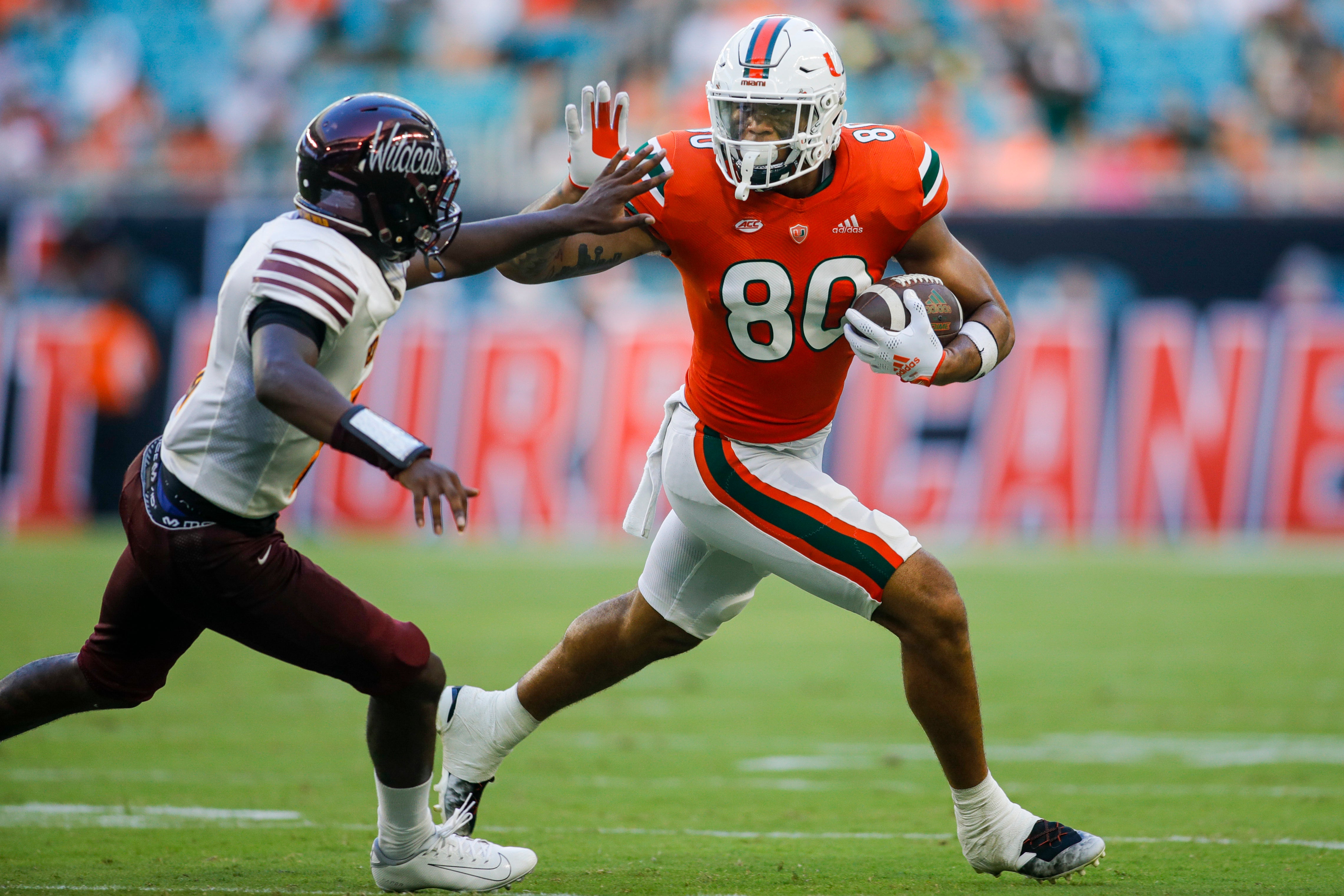 Sep 3, 2022; Miami Gardens, Florida, USA; Miami Hurricanes tight end Elijah Arroyo (80) runs with the football and protects it from Bethune Cookman Wildcats safety Jaquan Jackson (5) during the third quarter at Hard Rock Stadium.